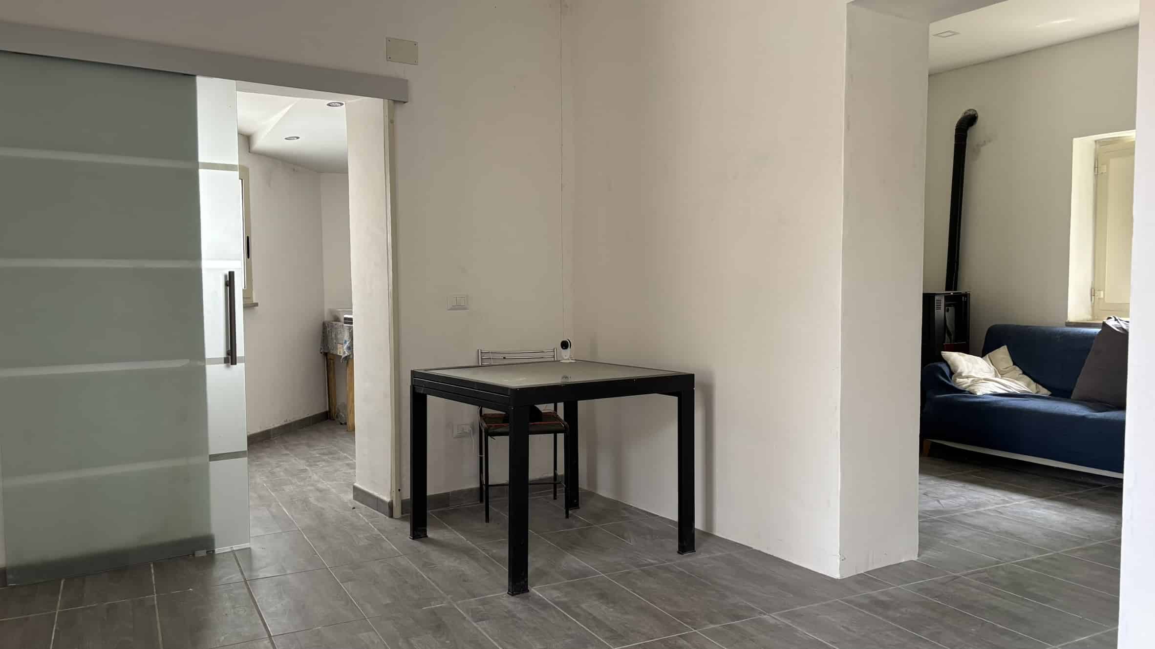Arredo moderno appartamento NextCasa, spazio abitativo con soggiorno e angolo cottura, pavimenti in gres, arredi funzionali, atmosfera luminosa, ideale per vivere in comfort e stile.