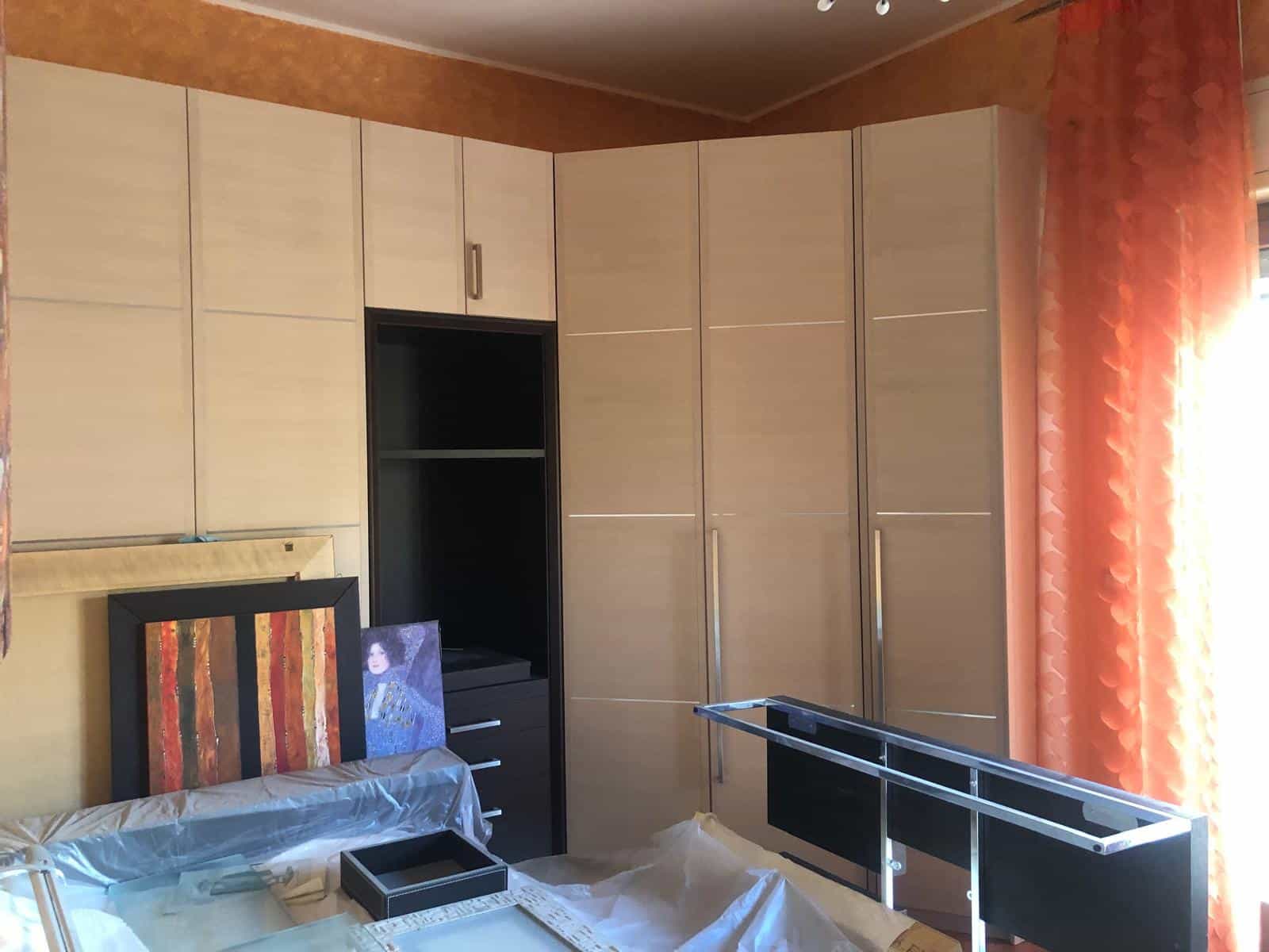 Armadio a muro con ante beige in soggiorno o camera da letto, ideale per organizzare gli spazi e ottimizzare gli ambienti domestici.