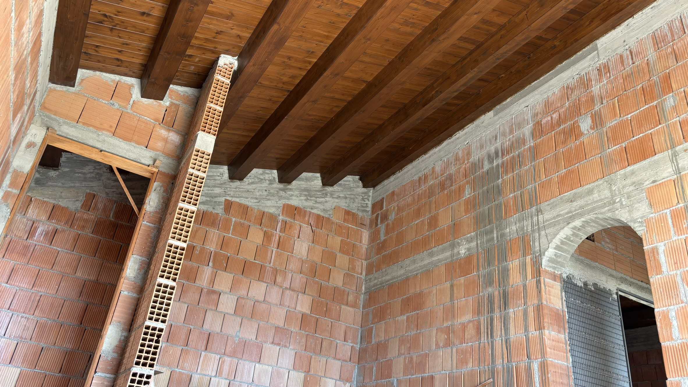 Fasi di costruzione di un edificio con pareti in laterizio e soffitto in legno, esempio di progetto edilizio NextCasa.