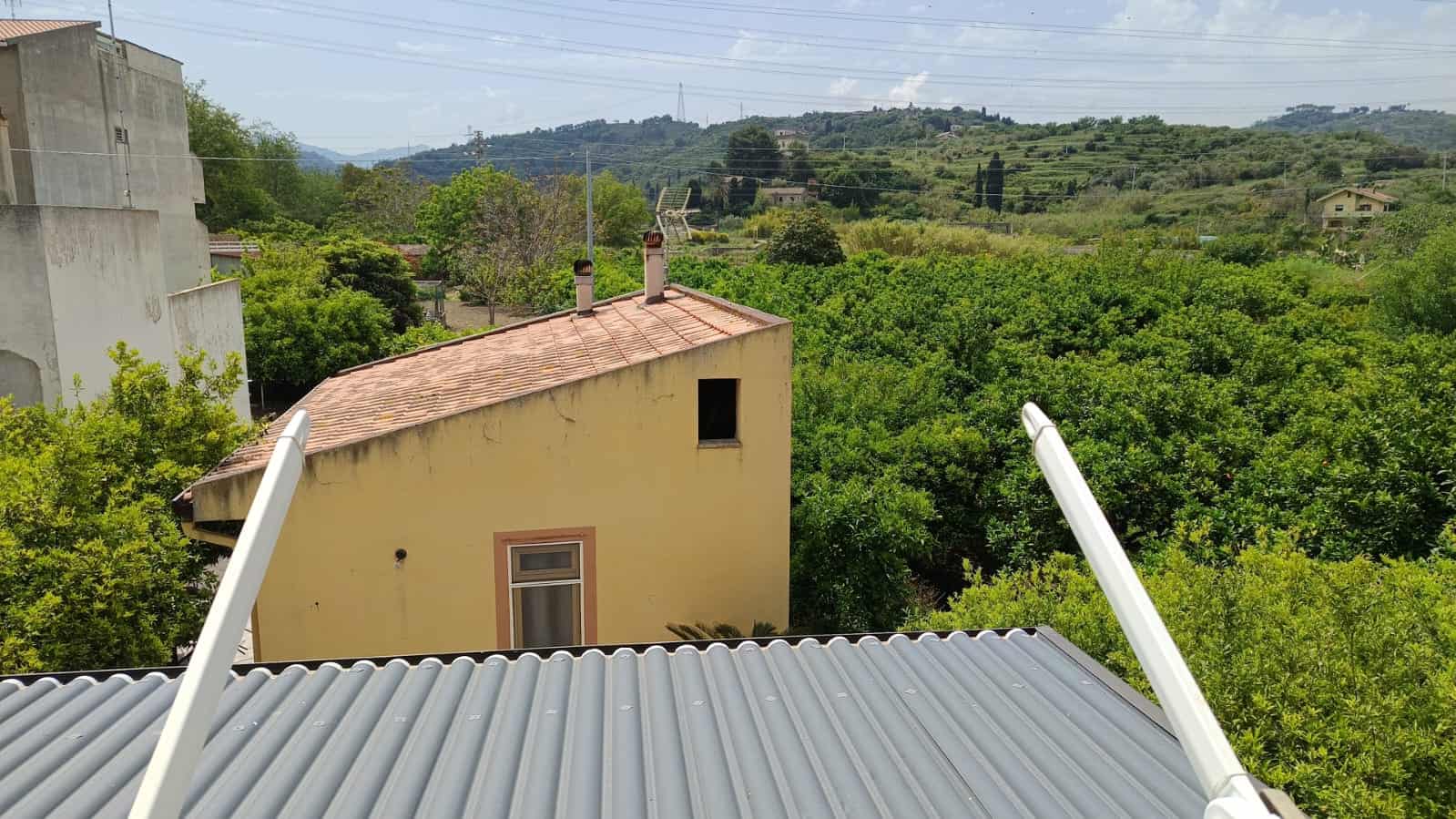 Balcone con vista sulle case e sulla natura circostante in un paesaggio rurale; immobili di charme in zona verde e tranquilla, perfetti per investimento immobiliare e casa vacanza.