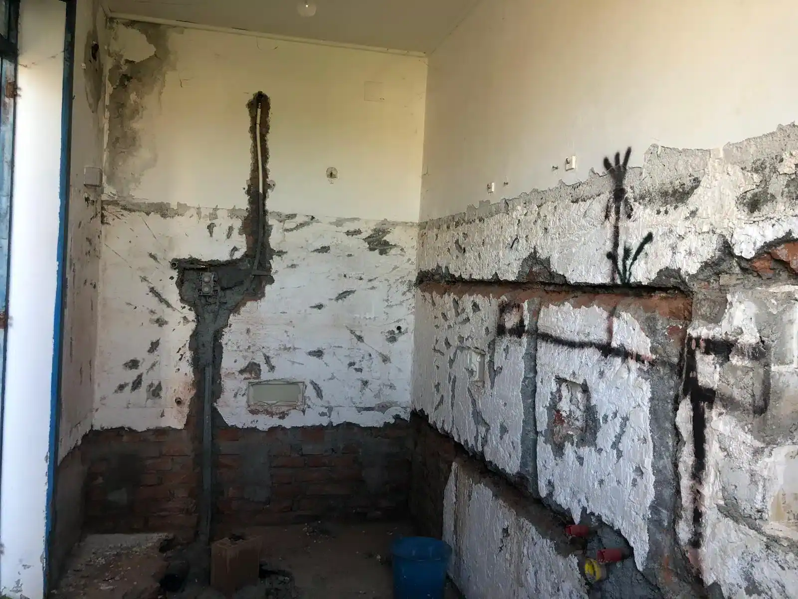 Interno di una casa in fase di ristrutturazione con pareti in muratura e impianti elettrici visibili, in zona Piazza Pozzo 21, Milazzo.