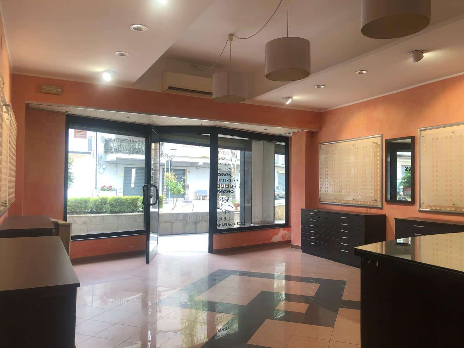 Vetrina commerciale con ampie finestre, arredamento moderno e esposizione luminoso, ideale per negozio o ufficio in zona centrale.