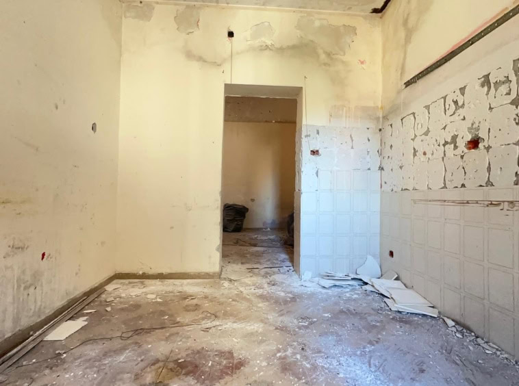 Fondo di una stanza in ristrutturazione, pareti con tracce di lavori ed è in fase di rinnovo.