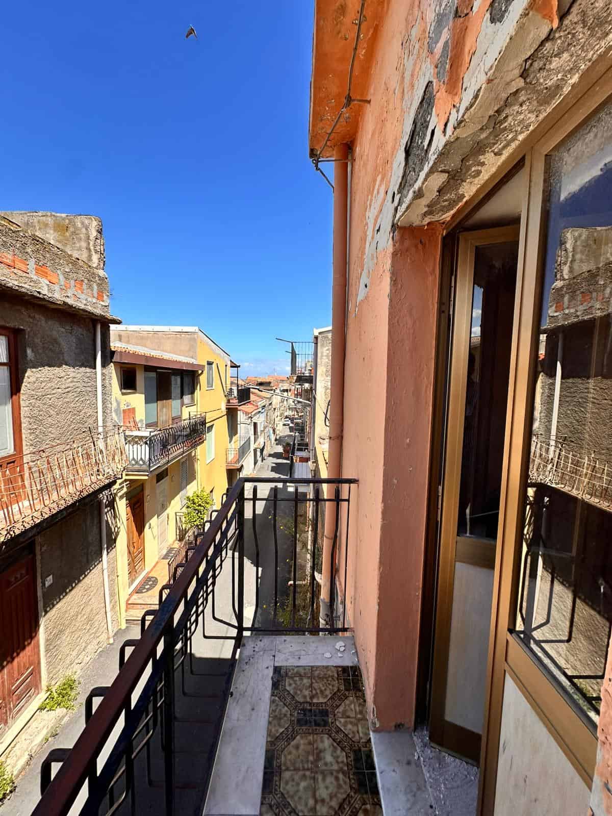 Balcone di un appartamento nel centro storico, con vista sulle facciate delle case colorate e le vie del quartiere, in un’immagine di edilizia residenziale urbana.