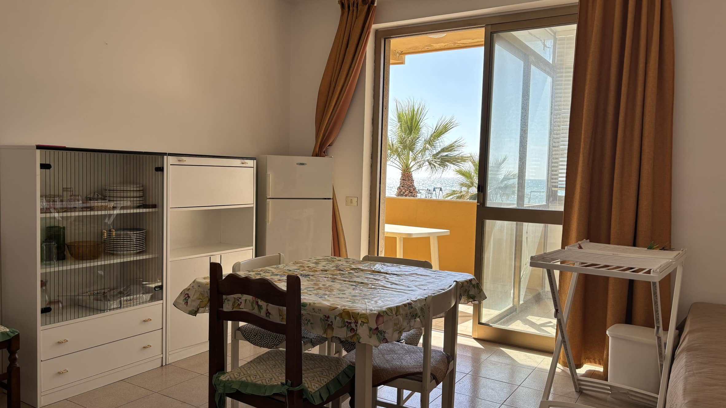 Atmosfera confortabile in appartamento con balcone vista mare, arredato con mobili pratici, perfetto per vivere vicino alla spiaggia e godersi il clima mediterraneo.