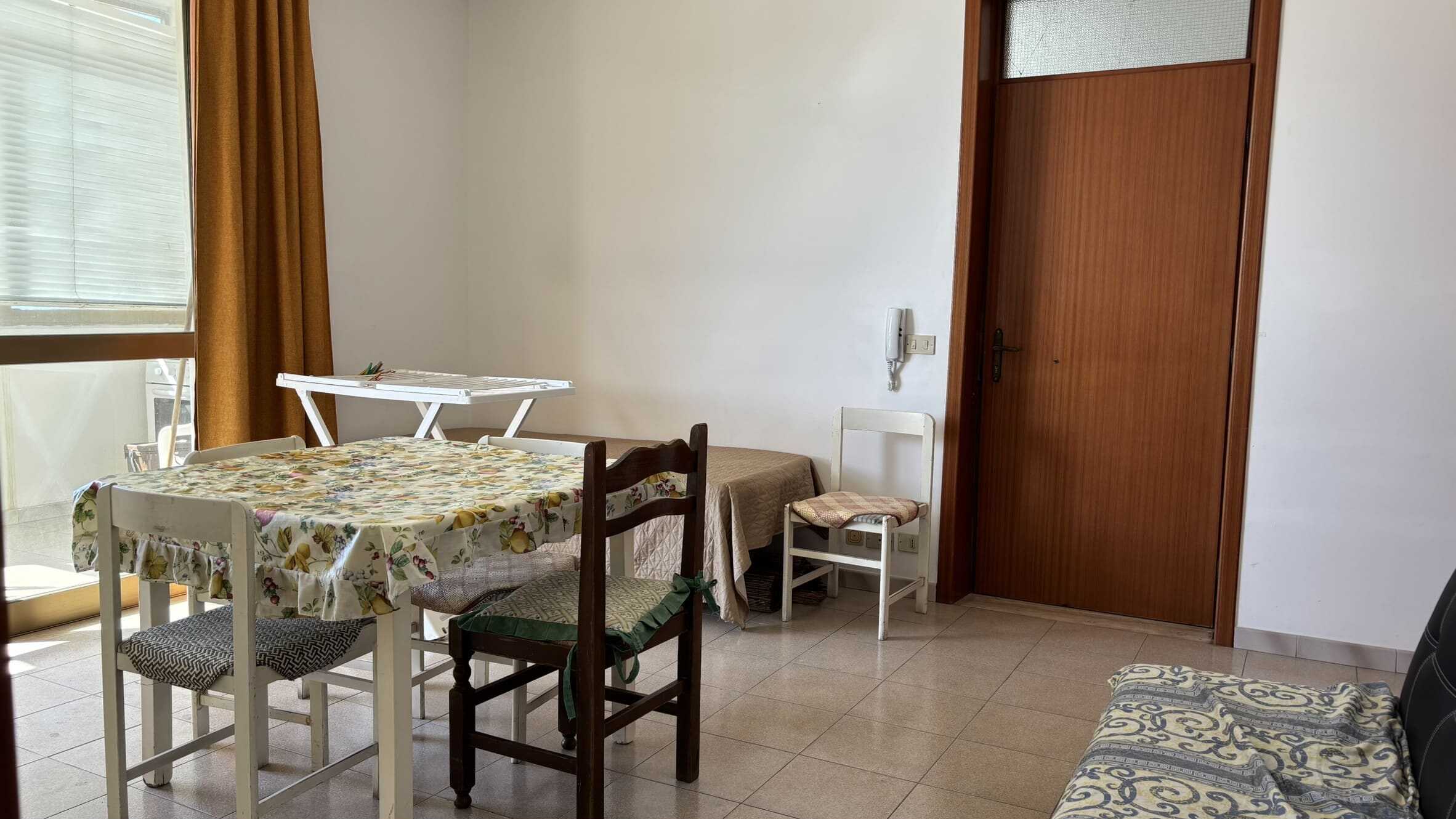 Soggiorno con tavolo da pranzo, sedie e accessori in stile classico in un appartamento in affitto a NextCasa.