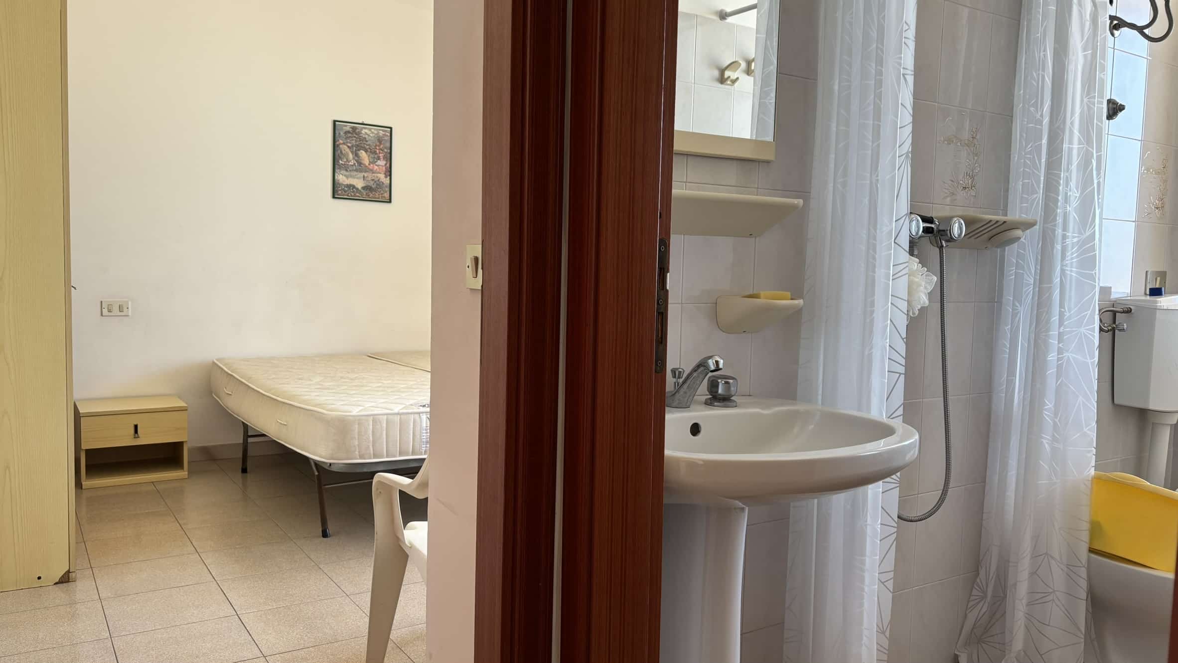 Camere da letto e bagno Casa in affitto a NextCasa, ambiente accogliente, arredi funzionali, pratico bagno con doccia e lavandino, ideale per soggiorni confortevoli e brevi.