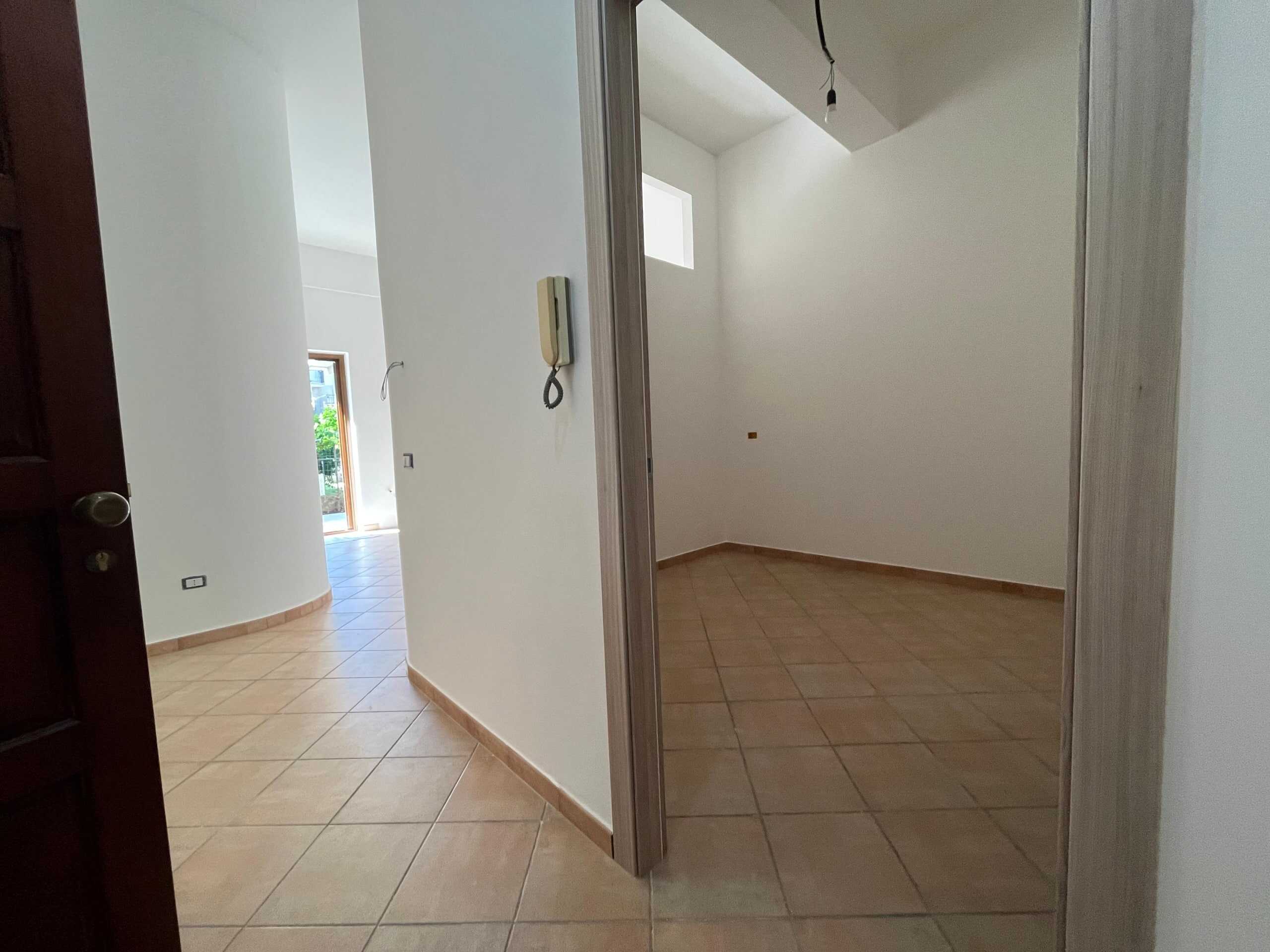 Spazi interni di un appartamento in fase di ristrutturazione con pareti bianche e pavimenti in ceramica chiara, pronti ad essere personalizzati per la vendita o l'affitto.