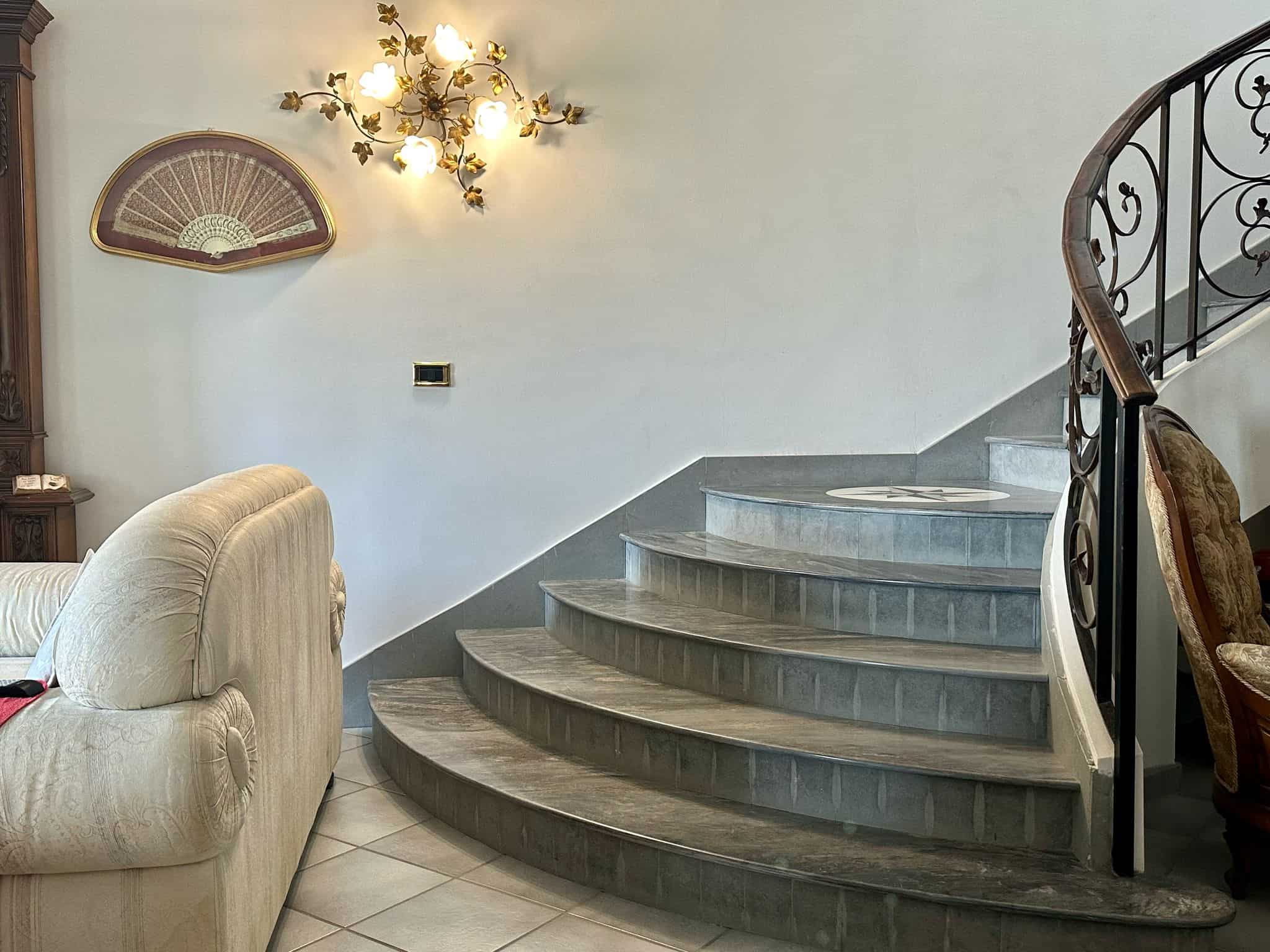 Elegante scala in marmo con ringhiera in ferro battuto, stile classico, arredamento di lusso, ambienti interni raffinati, casa di alta qualità.
