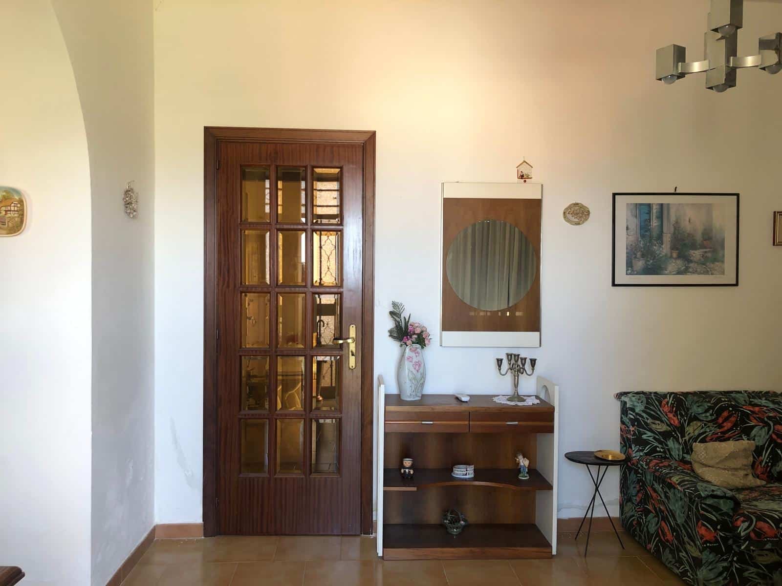 Moderno porta in legno con vetri decorativi, arredo semplice e dettagli di decorazione vintage, soggiorno accogliente, decorazioni floreali e quadri su parete, stile tradizionale.