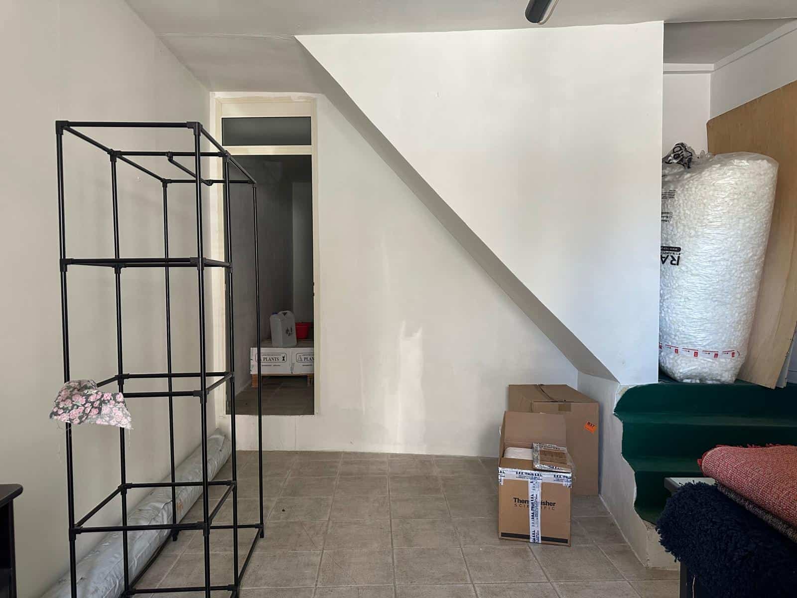 Stanza in fase di ristrutturazione con scatoloni e materiali da imballaggio, ideale per immagini di rinnovamento e arredamento per annunci immobiliari NextCasa.