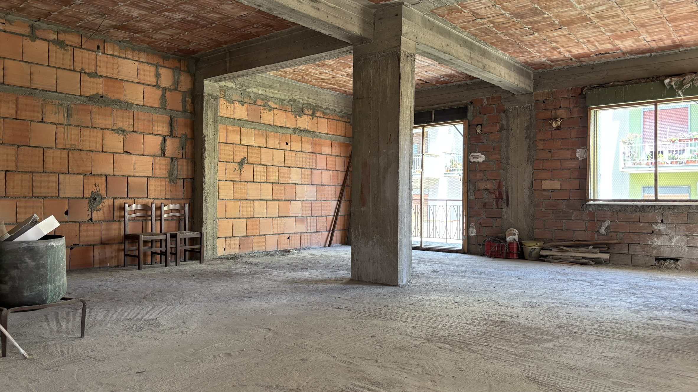 Muratura in costruzione di un appartamento residenziale in fase di rinnovamento, con pareti in mattoni e strutture in cemento armato, pronto per finiture interne.