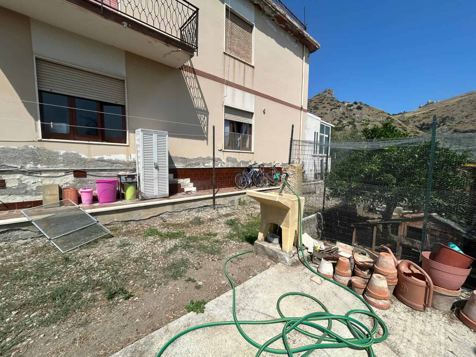 Potenziale piante e giardino esterno con fontana e attrezzi per il giardinaggio, edificio residenziale in stile mediterraneo, vista sulle colline, outdoor con arredi per cura del verde, rifiuti e attrezzature vari.