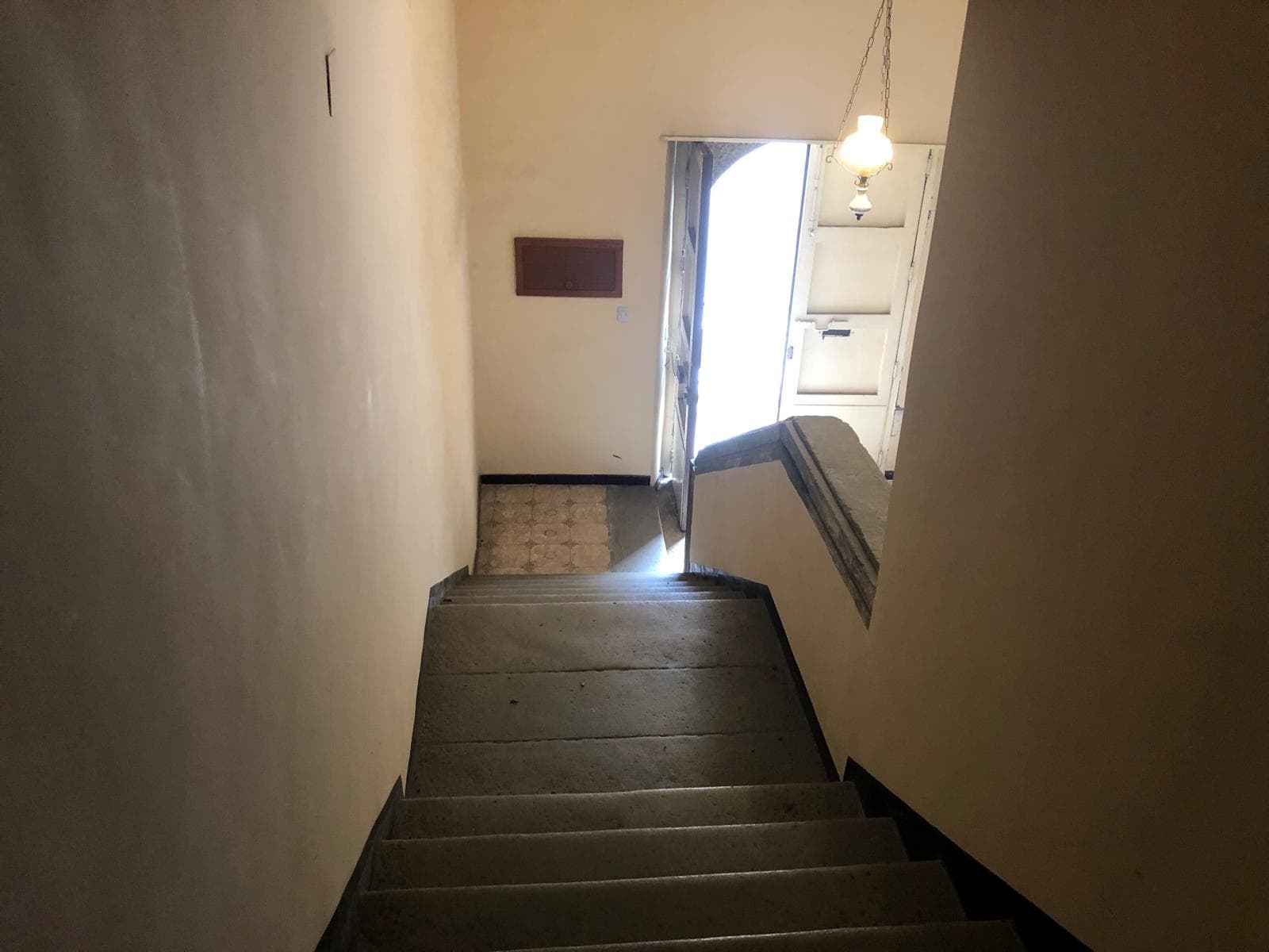 Scalinata interna di un appartamento con ingresso, pareti chiare e luce naturale, stile semplice e funzionale, in una zona abitativa tranquilla.