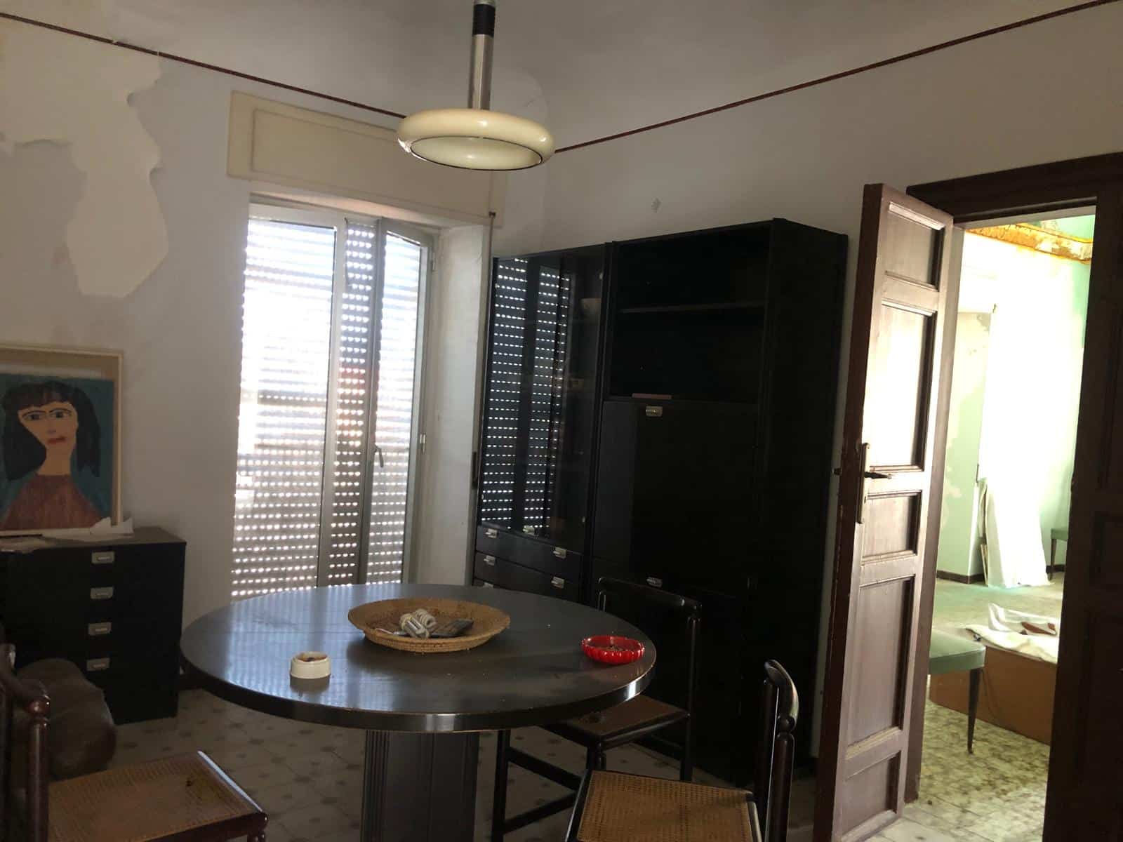 Vecchio appartamento con soggiorno dotato di porta-finestra e arredamento vintage, con cucina separata e camere da letto situate a Firenze. Ideale per investimento immobiliare o riqualificazione.
