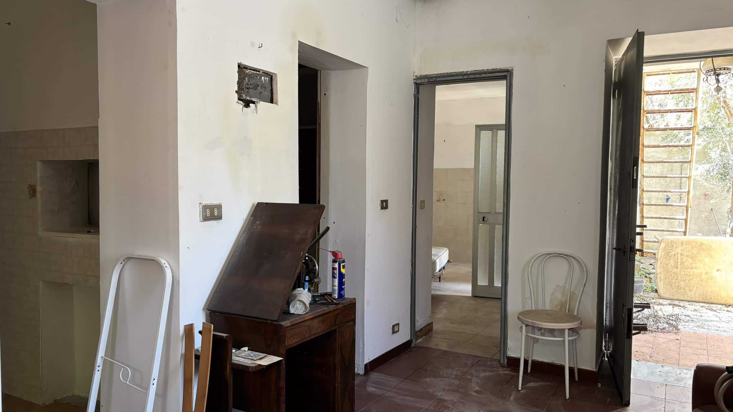 Finestra e porta di legno e vetro sopra un balcone con vista su un giardino, ambientazione di una casa in fase di ristrutturazione, stile semplice e funzionale, progettazione di interni, NextCasa.