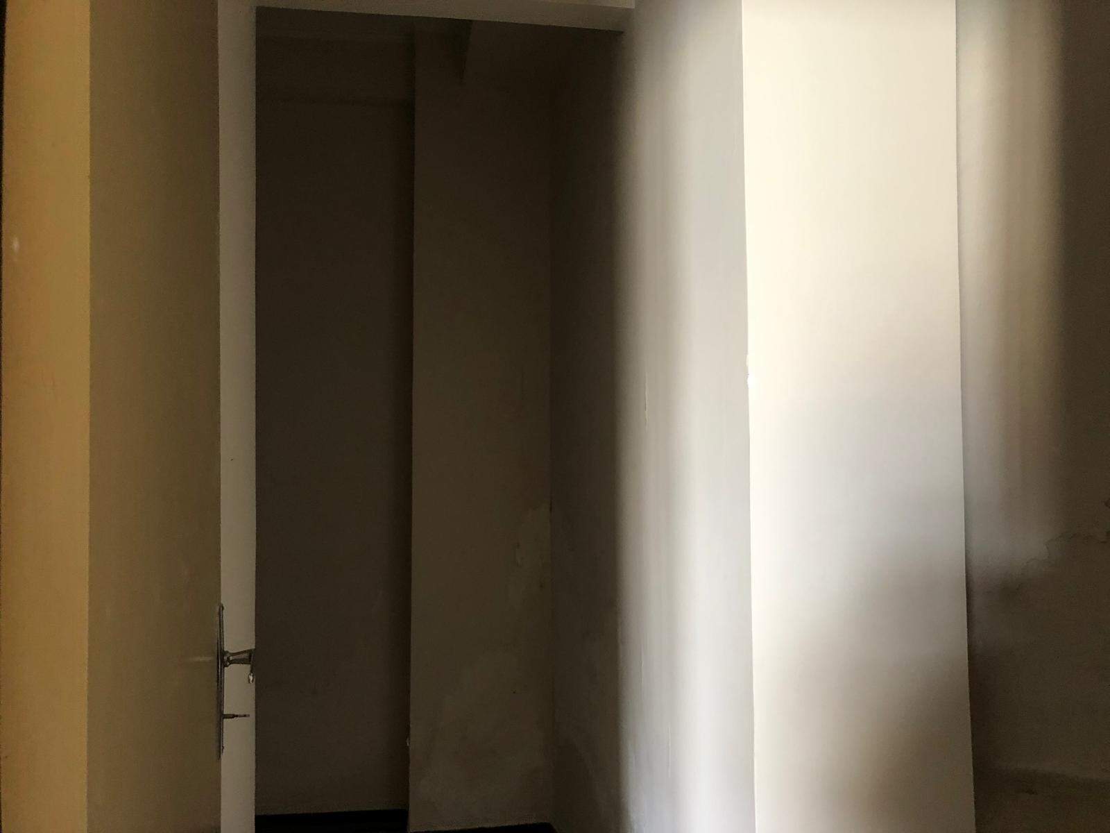 Armadio a muro con ante bianche in spazio abitativo moderno, ideale per l'organizzazione e lo stile della casa.