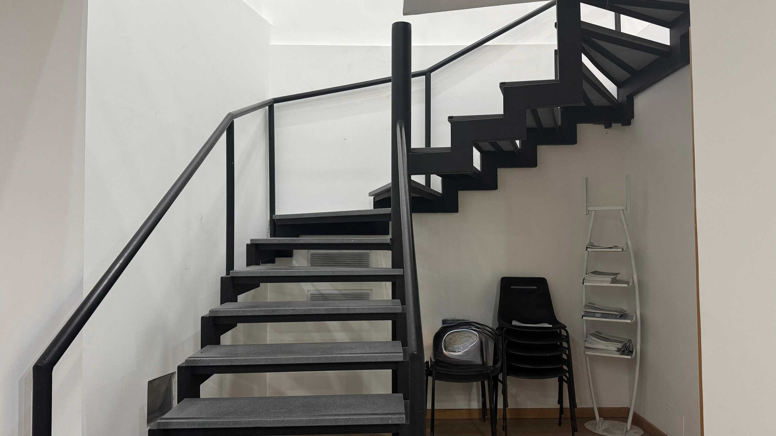 Scale interne in metallo nero con ringhiera, ambiente moderno casa, spazio abitativo luminoso, design minimalista, arredamento funzionale e pratico, occasione ristrutturazione edilizia, NextCasa.