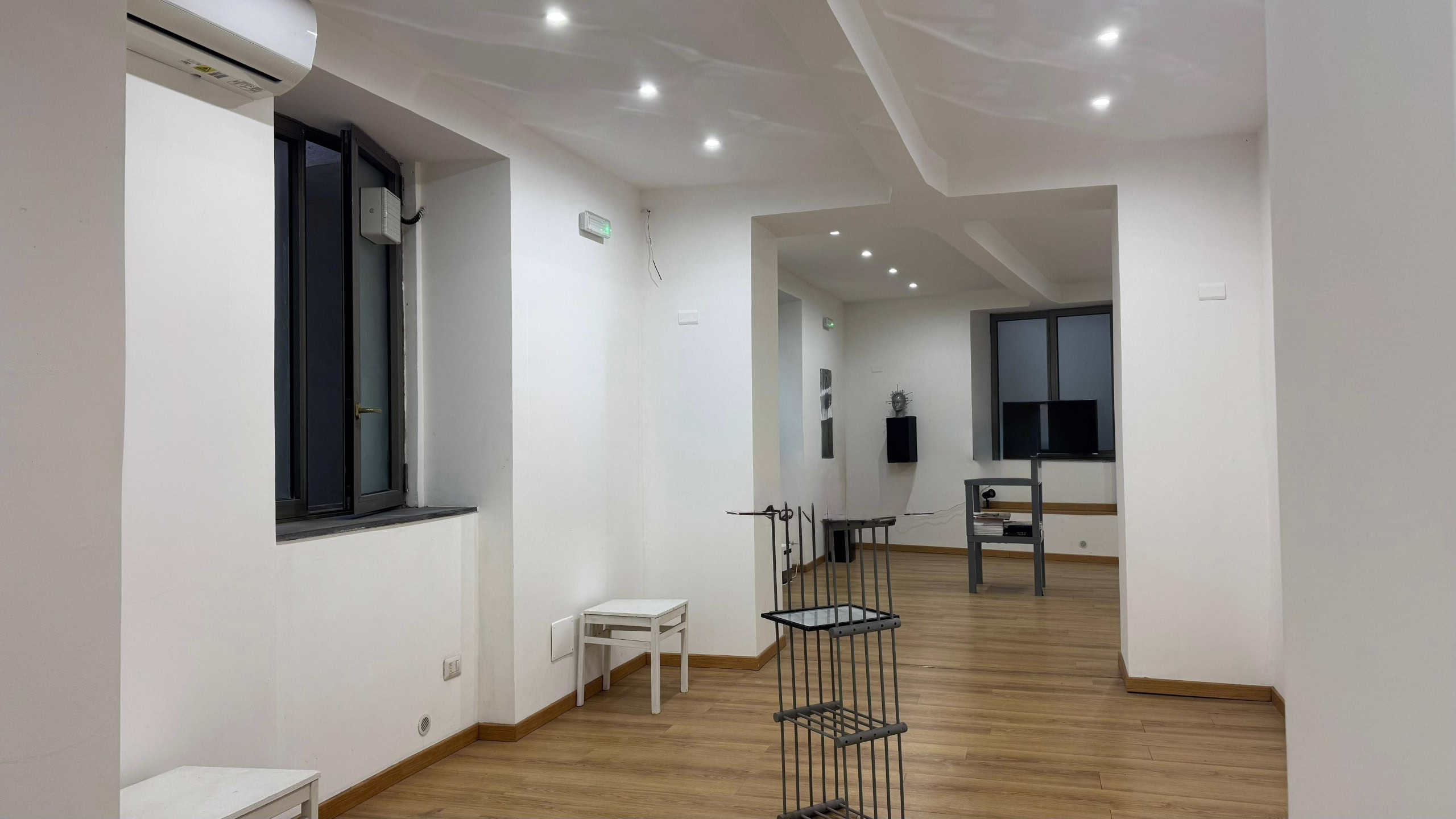 Elegante soggiorno moderno con pareti bianche, pavimento in parquet, finestre a taglio e illuminazione a led, arredi minimalisti e ambienti luminosi, ideale per case di design e living contemporanei.
