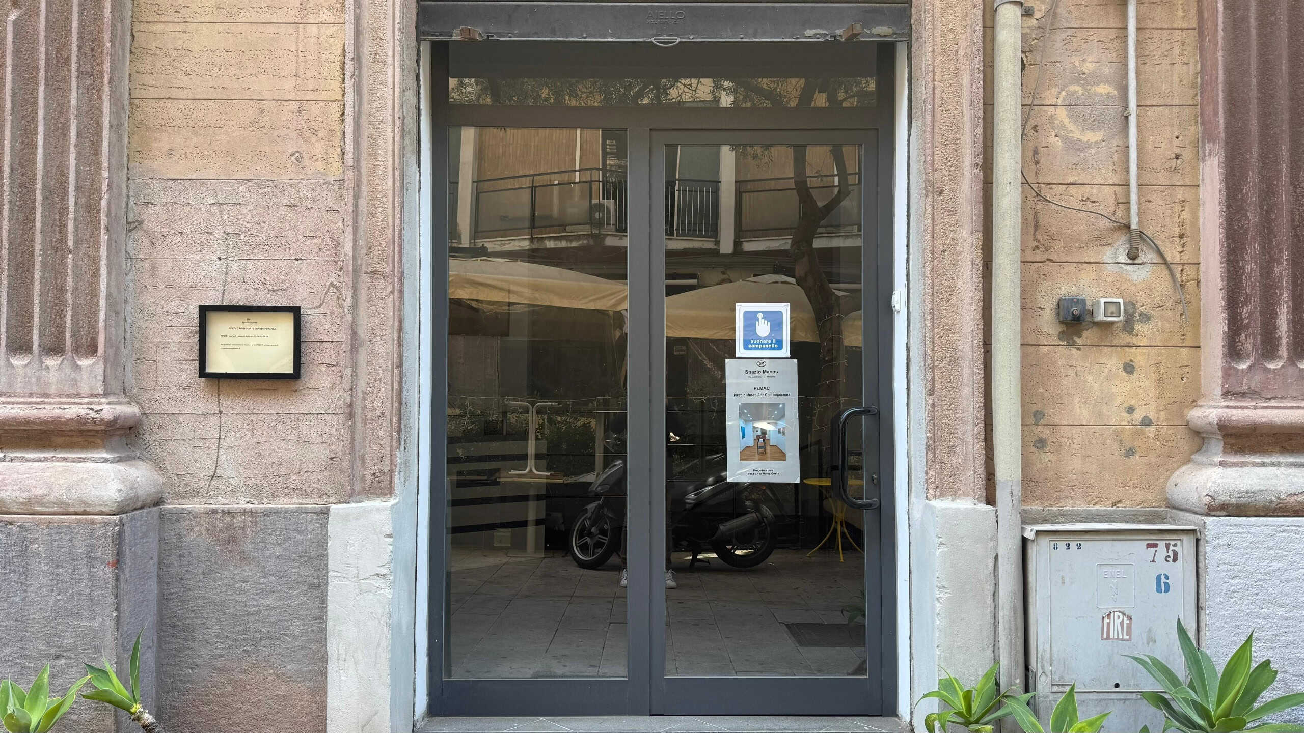 Porta d'ingresso in vetro con telaio in metallo, ingresso elegante e moderno, ideale per spazio commerciale o residenziale, con dettagli di design contemporaneo e sicurezza elevata.