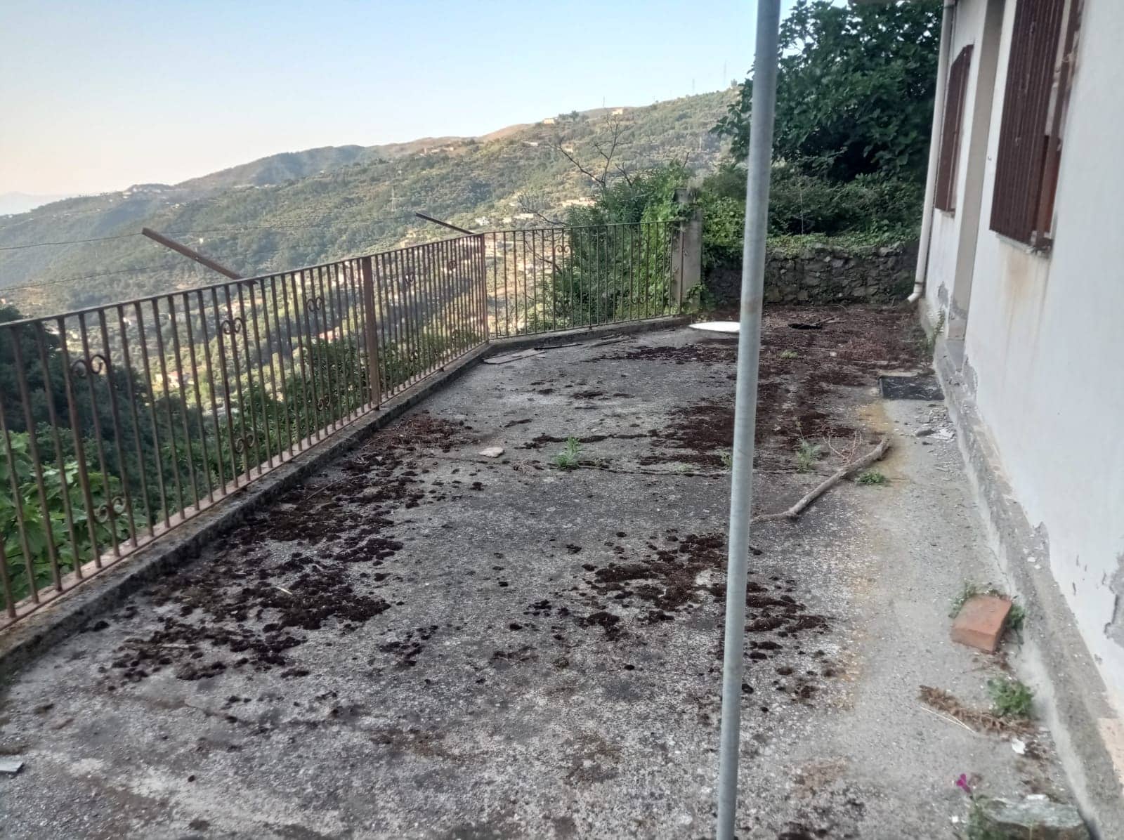 Balcone con vista sulle colline, pavimentazione in cemento e ringhiera in ferro, vicinanza a natura e paesaggi montani, ideale per relax e svago all'aperto, in posizione panoramica e tranquilla.