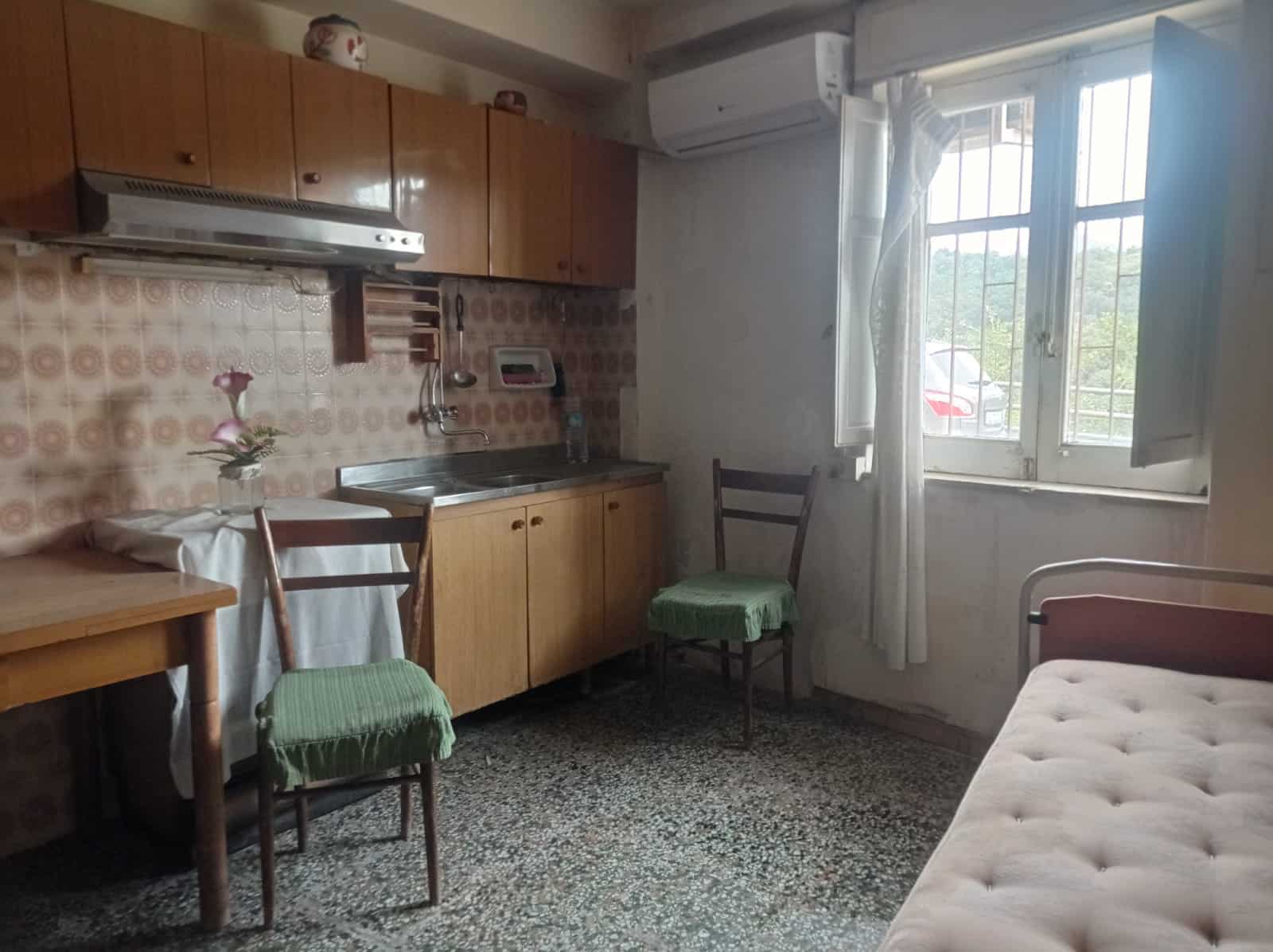 Casa vacanze con cucina tradizionale, mobili in legno, finestra con vista su giardino, ambiente accogliente e funzionale, ideale per affitti di breve o lungo termine.