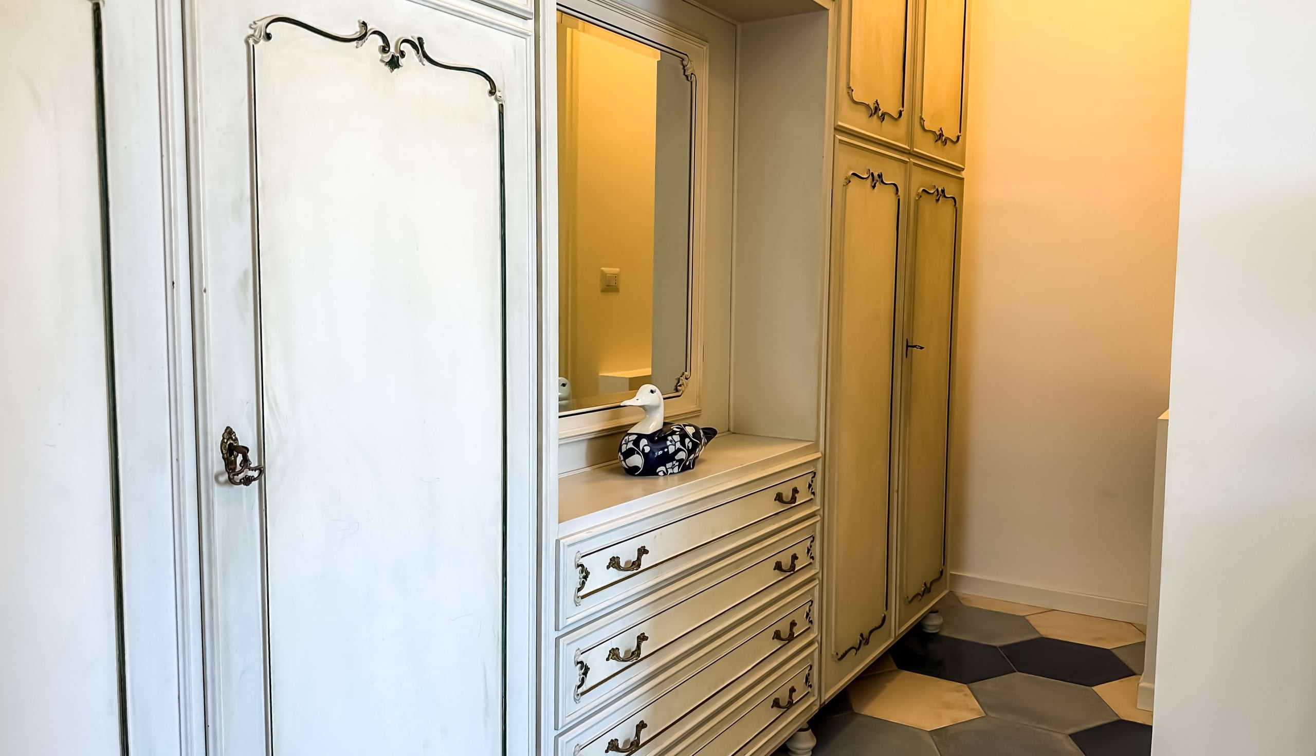 Armadio a muro classico con specchio e dettagli in stile vintage in un ingresso o camera da letto. Suggerimenti di arredo per ambienti eleganti e raffinati.