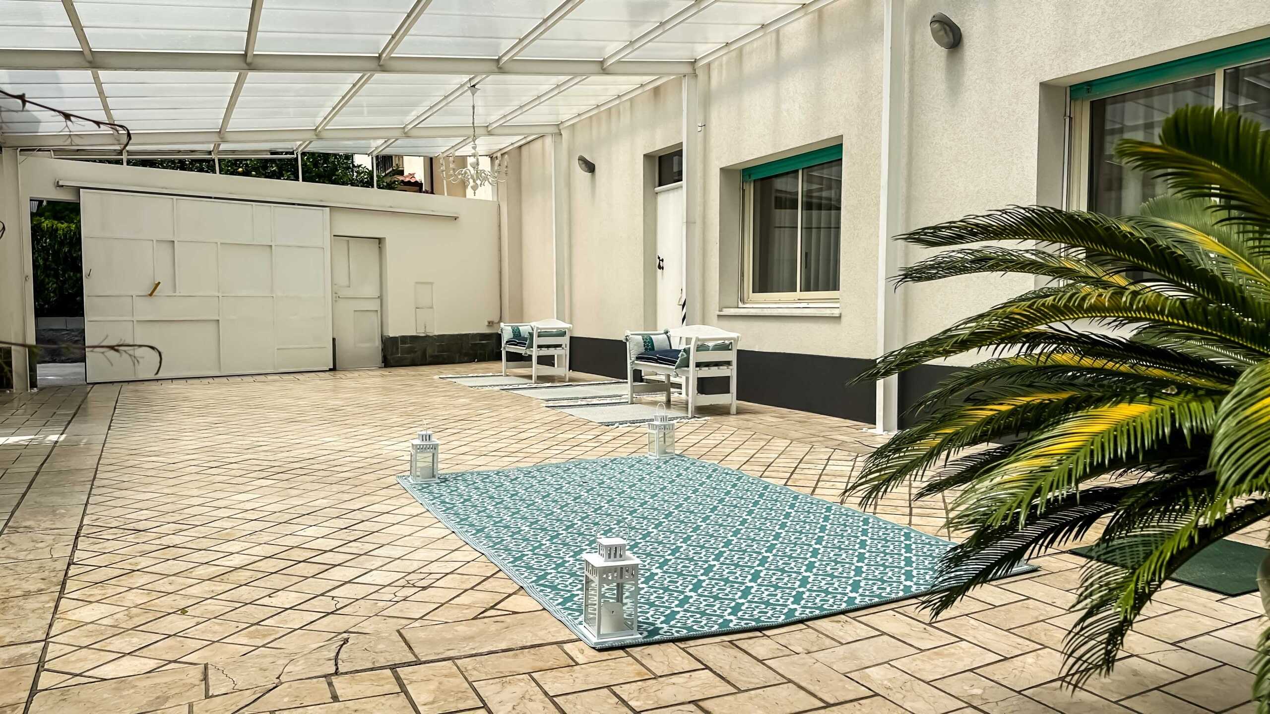Spazio esterno con pavimentazione in pietra, tende da sole e arredi per esterni, perfetto per relax e convivialità. Atmosfera accogliente e moderna, ideale per vivere il comfort di una casa vicino alla natura.
