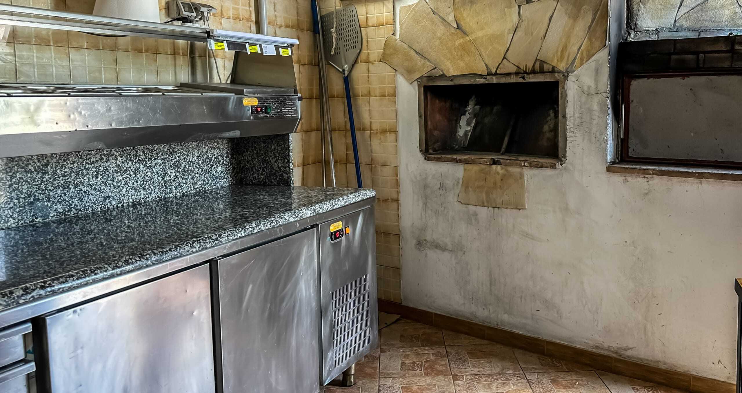 Fornelli da cucina professionali in acciaio inox con piano in granito in una cucina industriale.