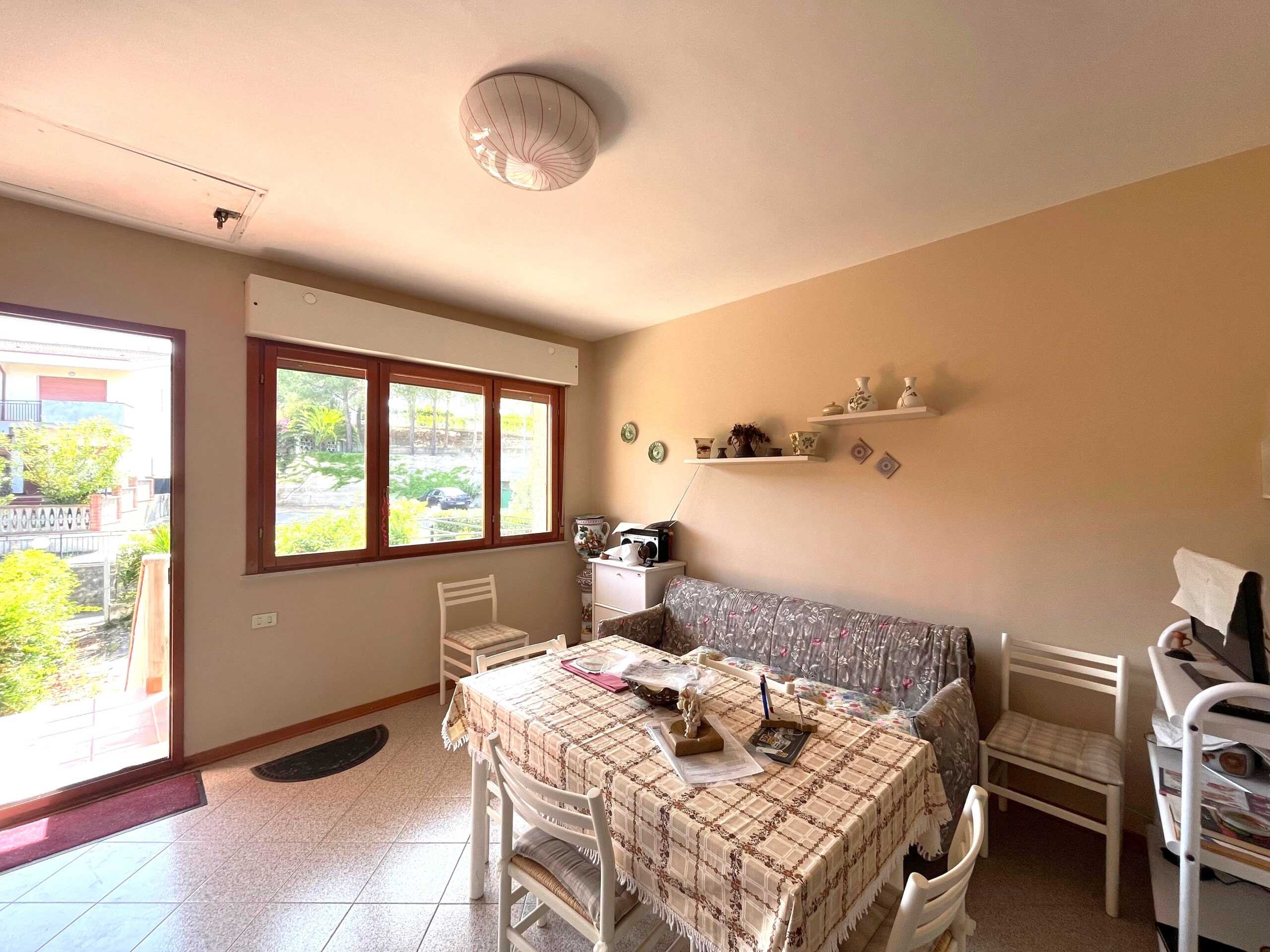 Finestra grande e luminosa in soggiorno con vista sul giardino, ambiente accogliente e arredamento pratico, ideale per vivere momenti di relax e convivialità in casa.