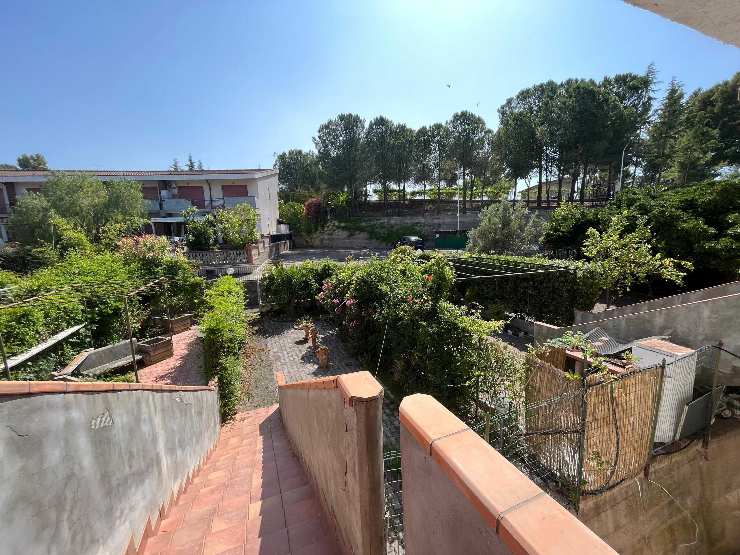 Vasto giardino con piante ornamentali e aree relax, vista sul verdeggiante quartiere residenziale, ideale per vivere in tranquillità, immersi nella natura, in un ambiente accogliente e ben curato.