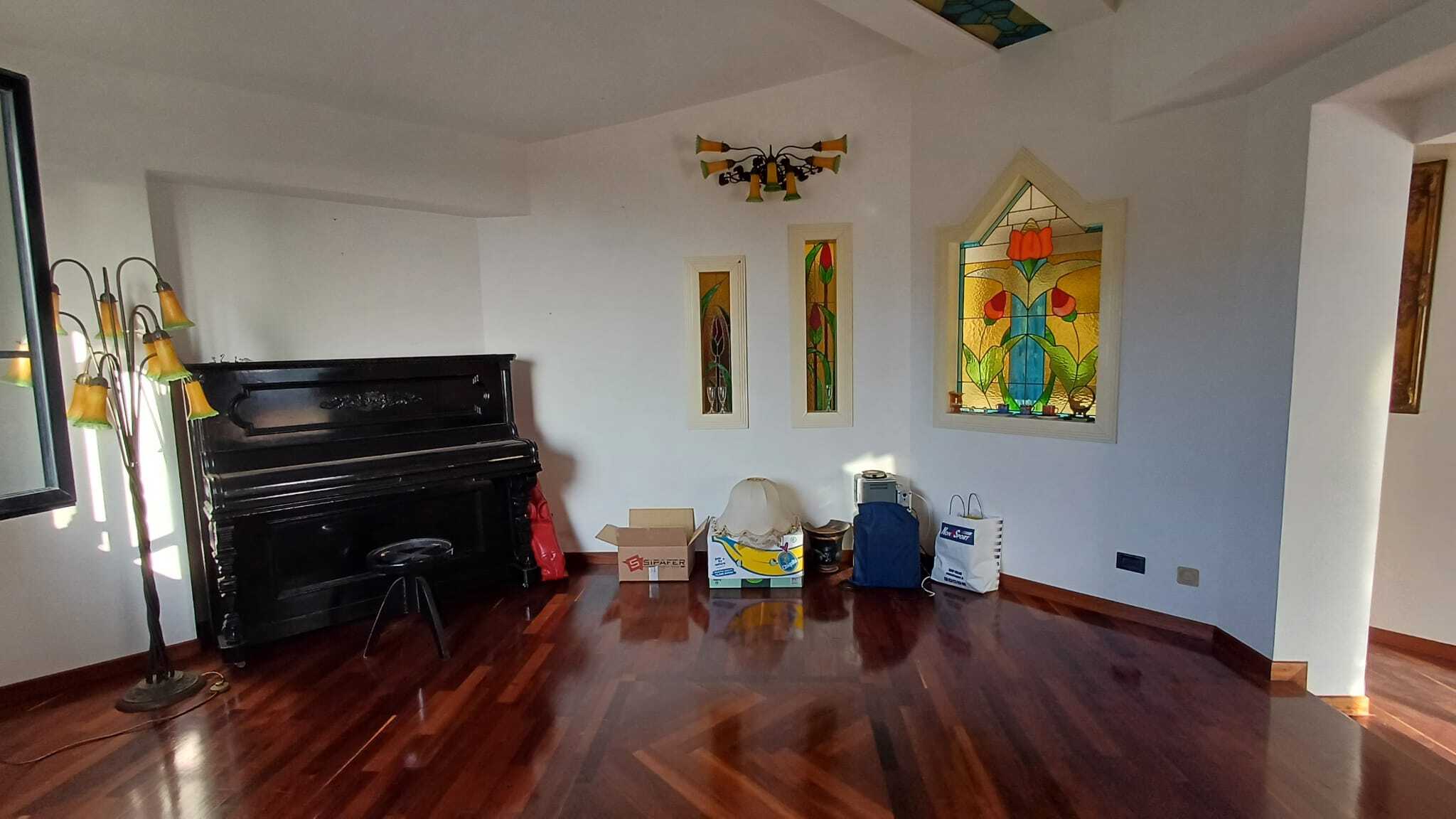Piantina interni casa con arredi e dettagli, pareti bianche, luminoso ambiente con sedie e lampade, finestre con vetrate colorate. Interno elegante e accogliente, con pavimento in legno lucido.