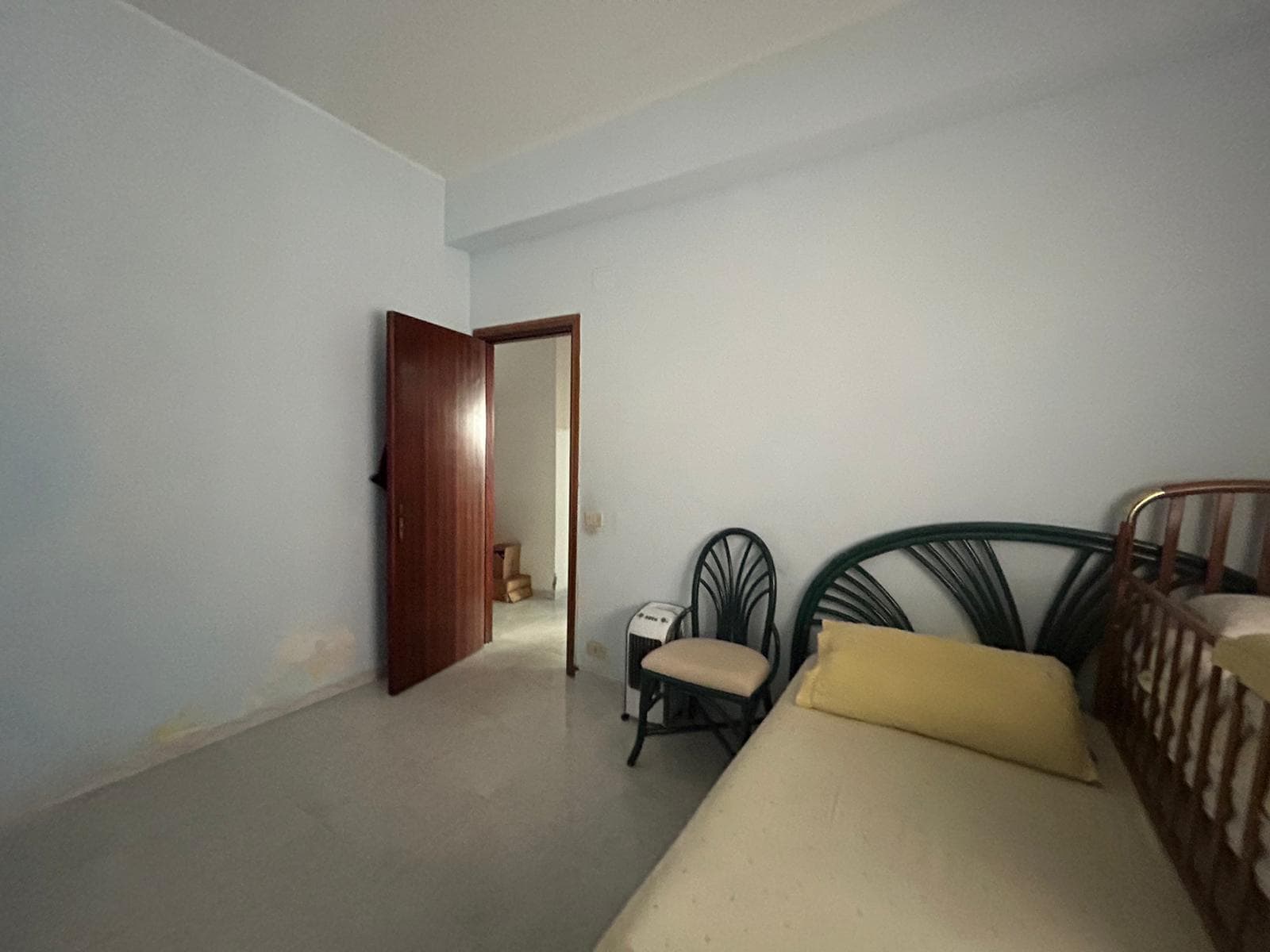 Camere da letto con arredi semplici e funzionali, pareti bianche, ingresso ed elementi di comfort come sedie e letto, ideale per affitti residenziali o investimenti immobiliari.