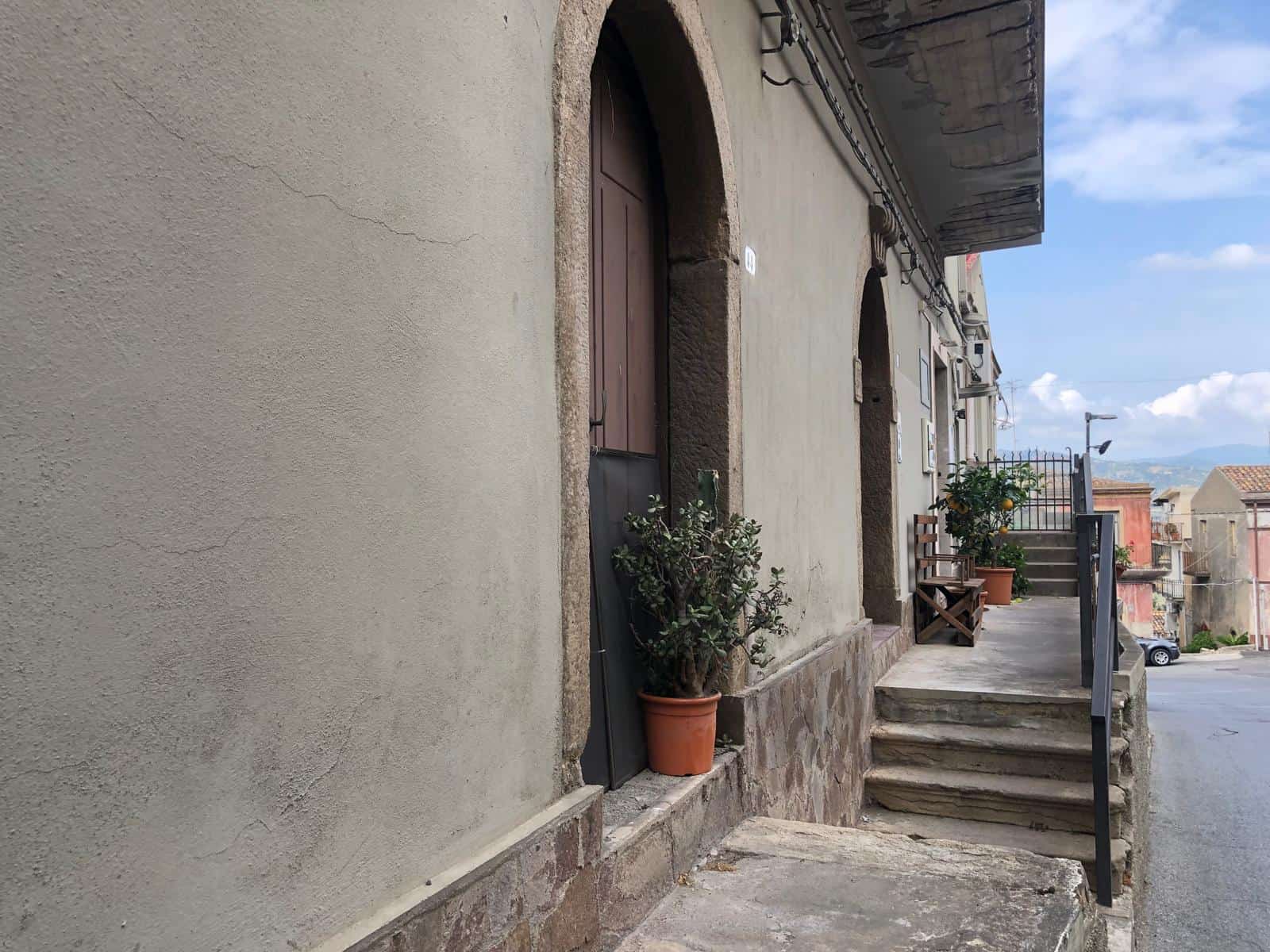 Rustico di zona centrale con ingresso indipendente e scale in pietra, piante in vaso e vista sulle case storiche, perfetto per ristrutturare casa in stile tradizionale.