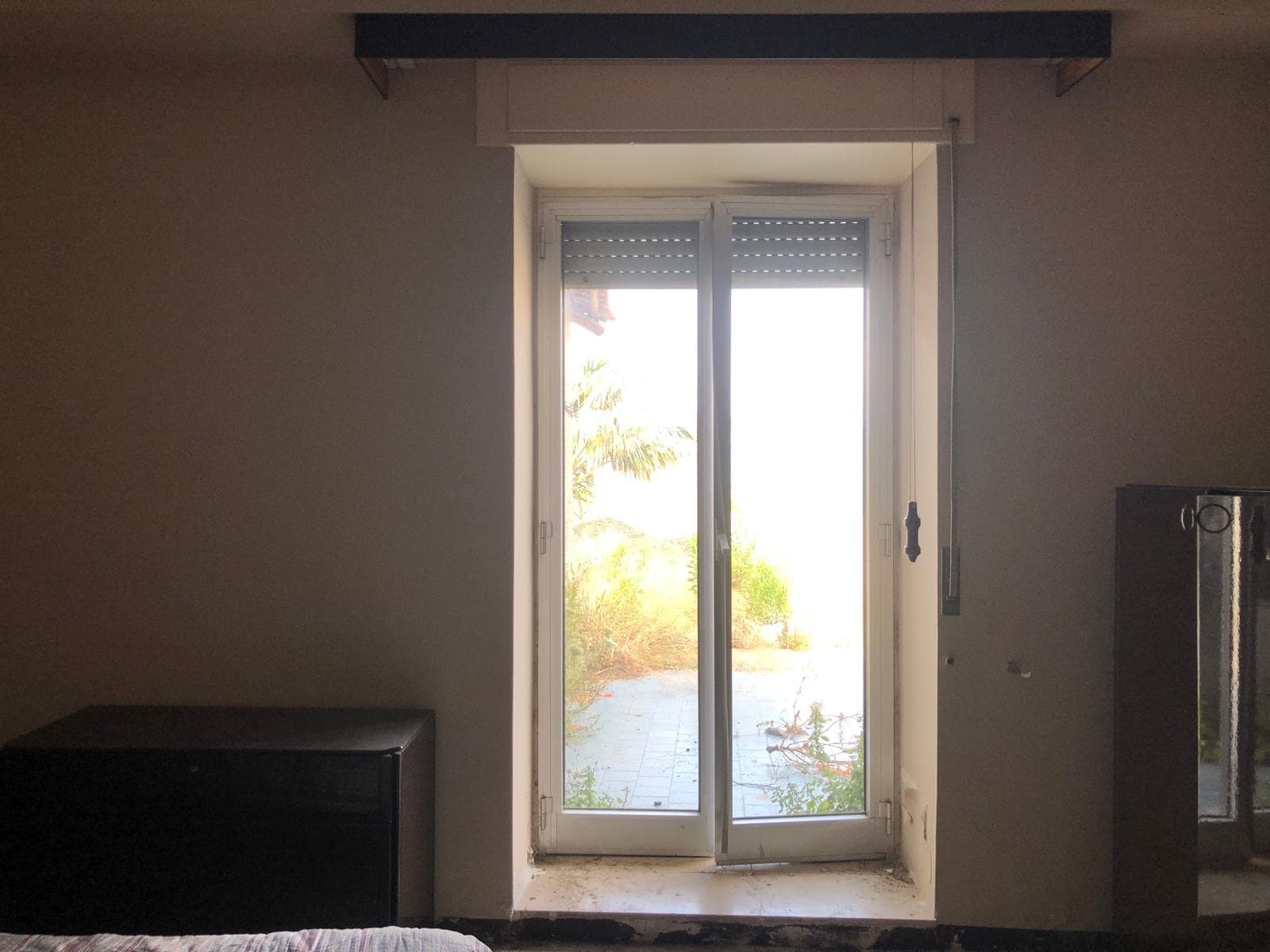 Finestra con vista su giardino privato, illuminazione naturale, all’interno di appartamento moderno, ideale per rivenditori immobiliari e agenzie di casa.