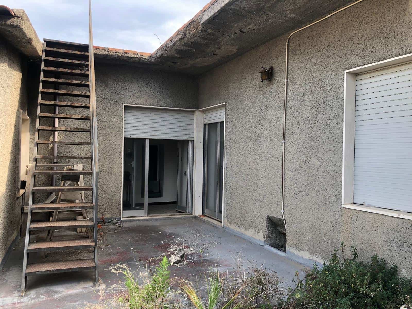 Scavo rivestito in cemento armato, lavori di ristrutturazione edilizia, balcone con ingresso in vetro scorrevole, pareti esterne con finitura in stucco, soluzione di recupero edilizio, edificio in fase di ristrutturazione, aggiornamento degli spazi esterni, costruzione di un nuovo terrazzo, progetto di restauro urbano, intervento di manutenzione edilizia.