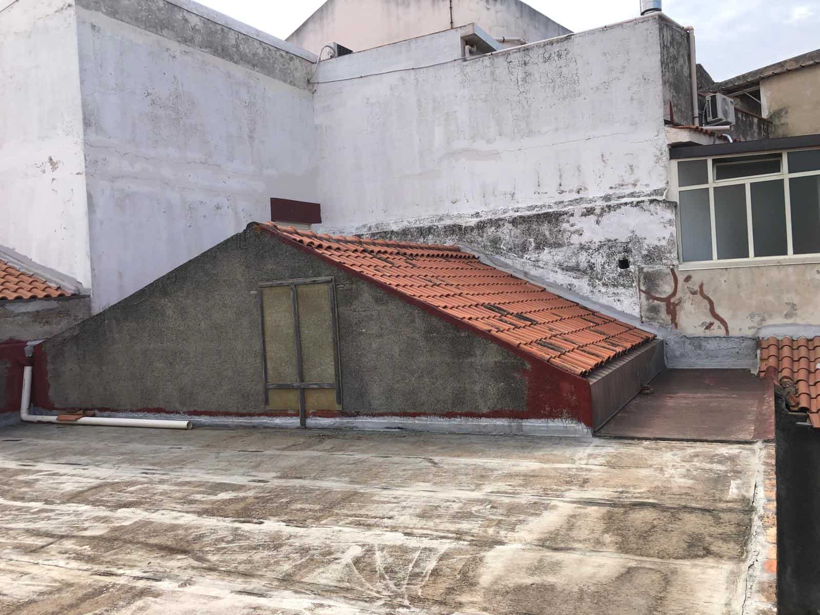 Tetto in tegole rosse su edifici urbani con esempio di copertura e muratura, vista da un terrazzo pavimentato, in contesto di ristrutturazione edilizia a Napoli.