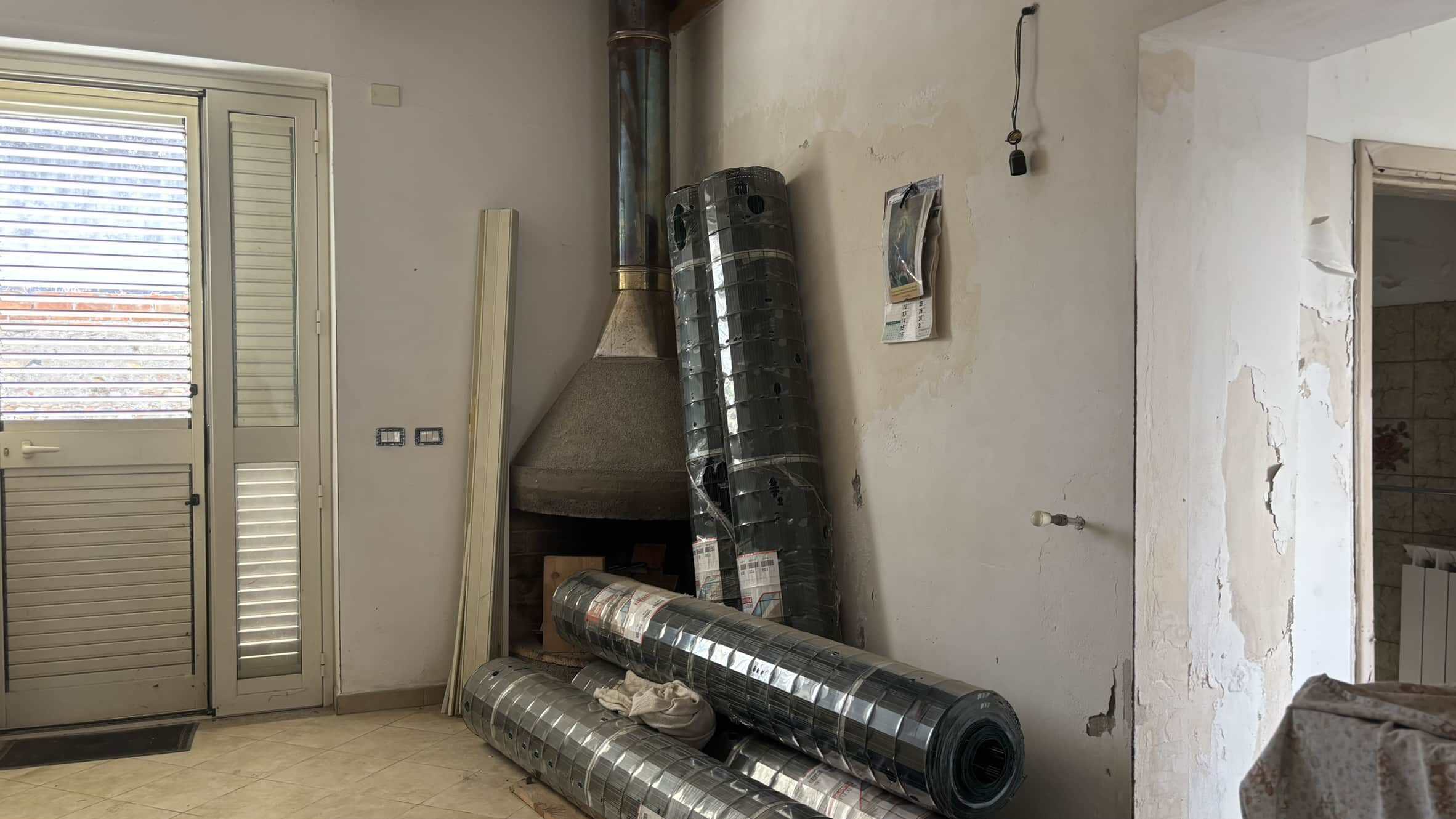 Tapparelle oscuranti in alluminio per finestre e porte, in fase di installazione, in una casa in ristrutturazione, con pareti da ritinteggiare ne ambiente domestico.