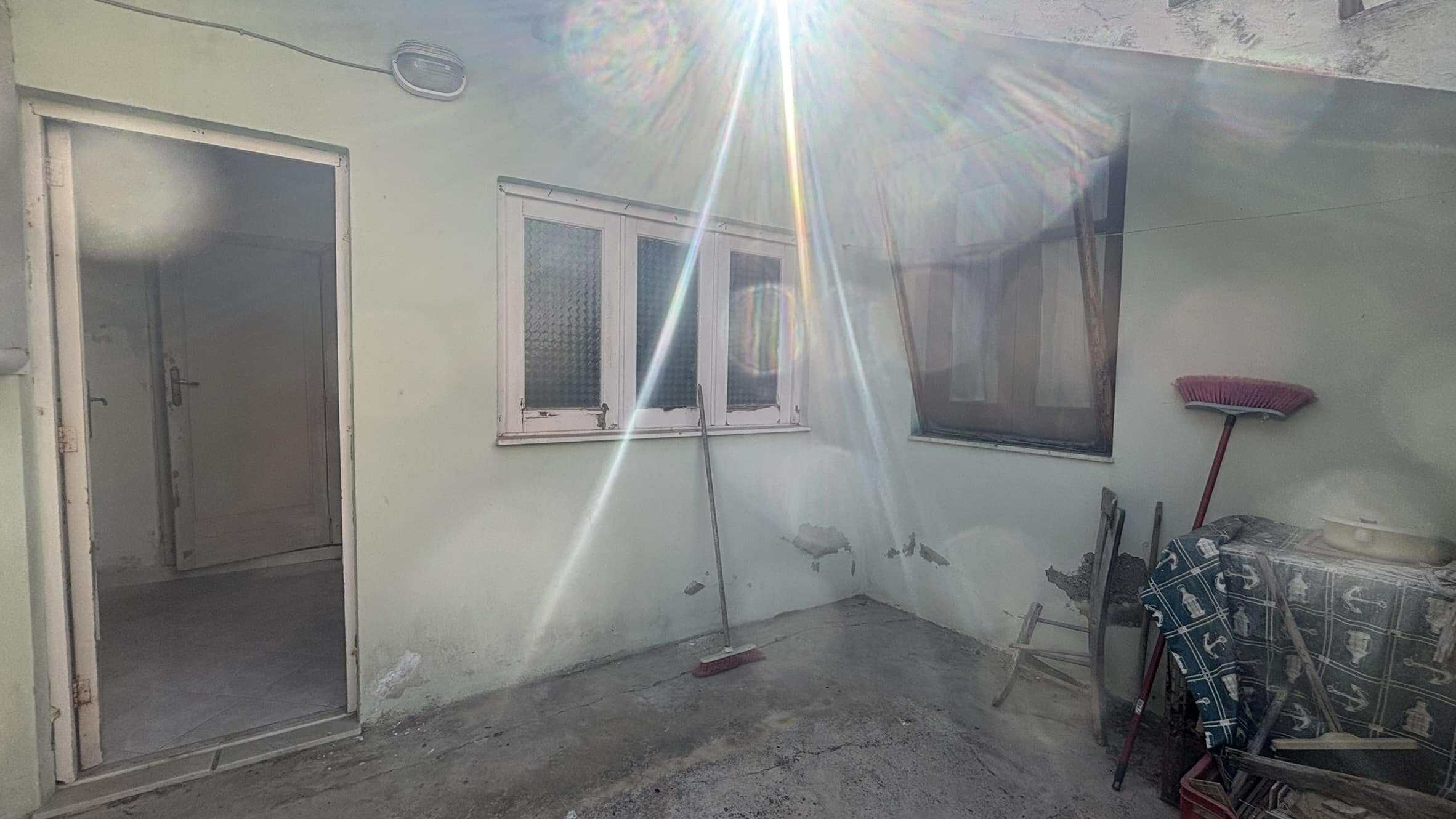 Finestra e porta di un appartamento in fase di ristrutturazione, interno da completare con dettagli moderni e funzionali. Luce naturale e ambiente semplice pronto per essere personalizzato.