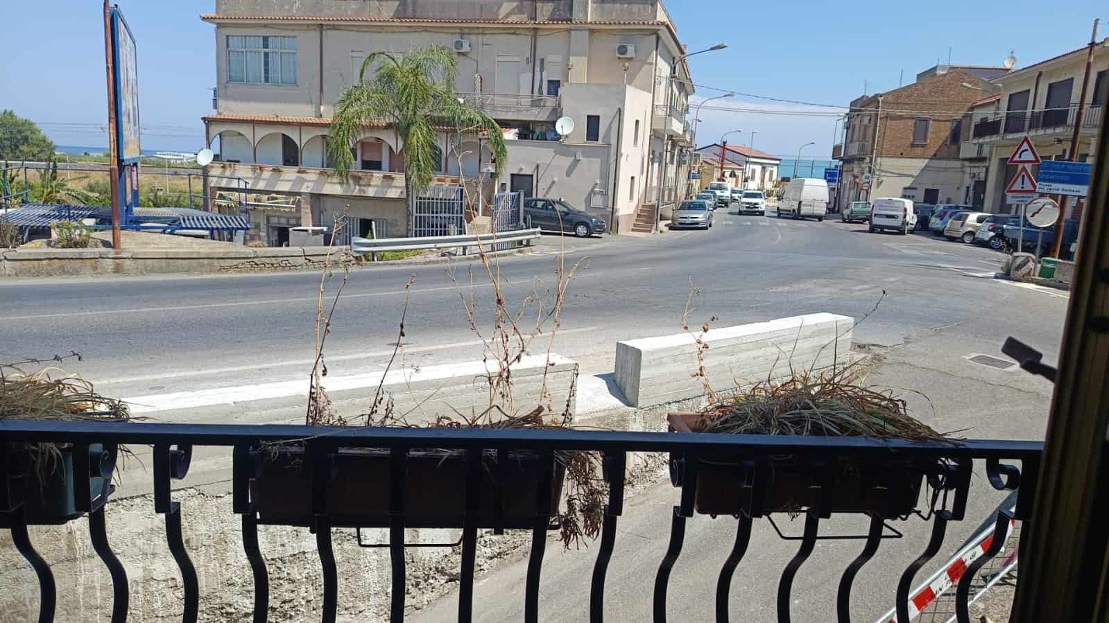 Vista strada panoramica con edifici residenziali e parcheggio, vista dalla finestra, immagini di immobili NextCasa, zona urbana, edilizia residenziale in Sicilia, strada trafficata, vista alla porta di casa, zona di città mediterranea, immagine di quartiere e vie cittadine.