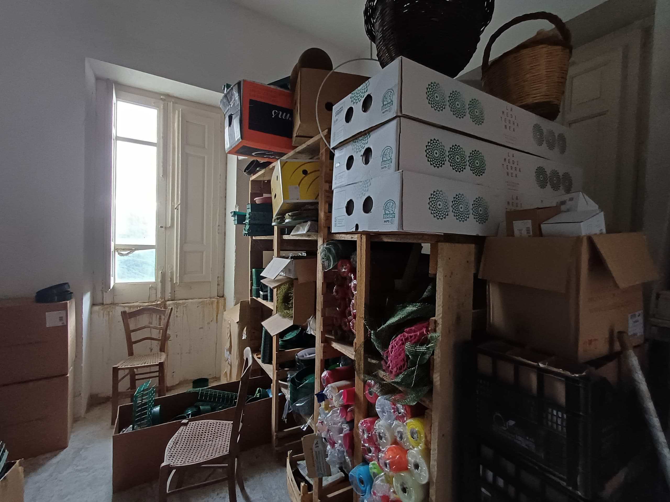 Scaffale con scatole e materiali da lavoro in un'officina o magazzino. ambiente con finestra grande e luce naturale.