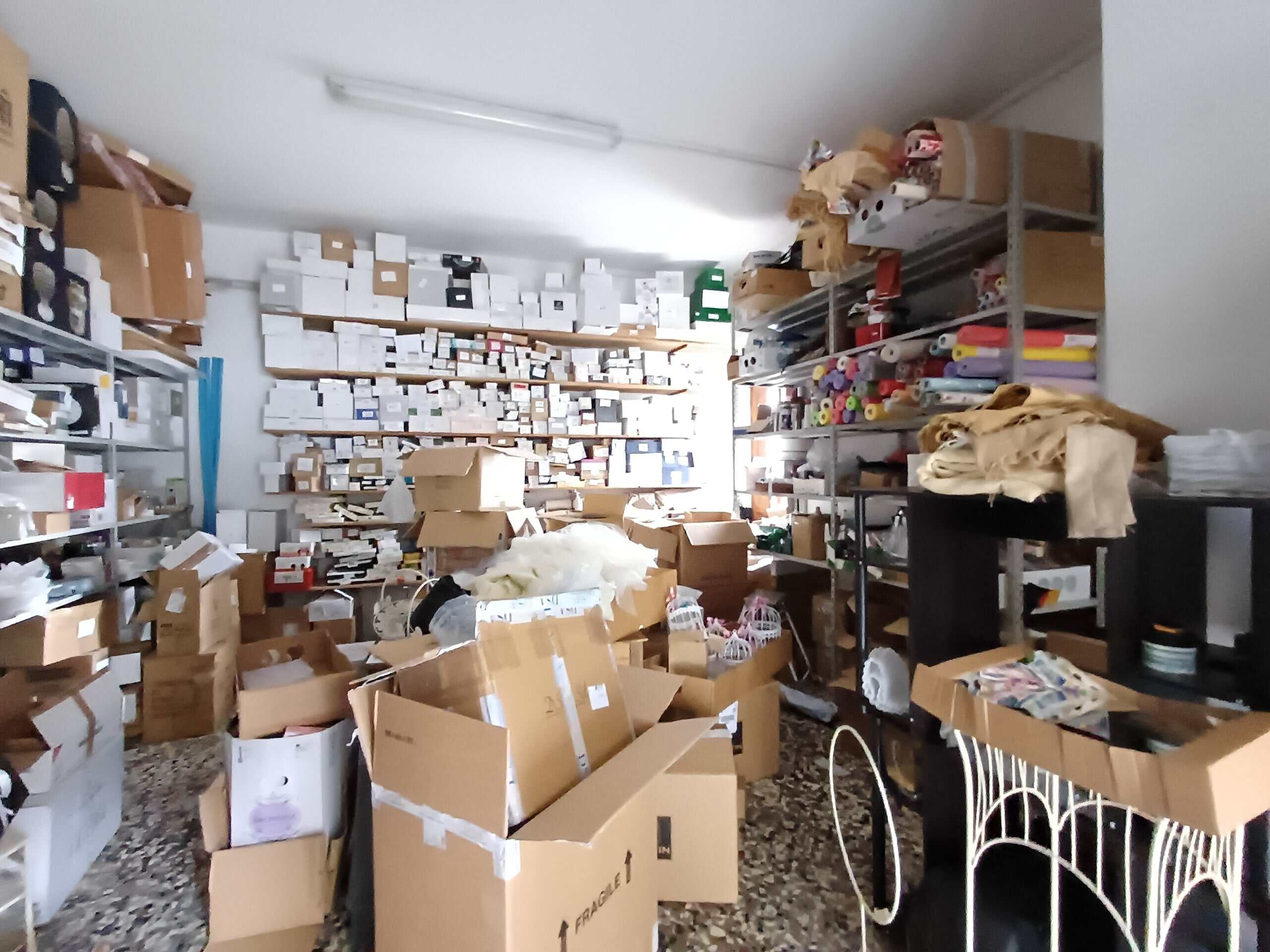 Scaffale di magazzino con scatole e materiali di spedizione, ambiente di stoccaggio per negozio o logistica.