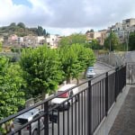 Veranda con vista su strada e case nel quartiere storico di NextCasa, con alberi verdeggianti e panorama urbano, ideale per relax e vita quotidiana.