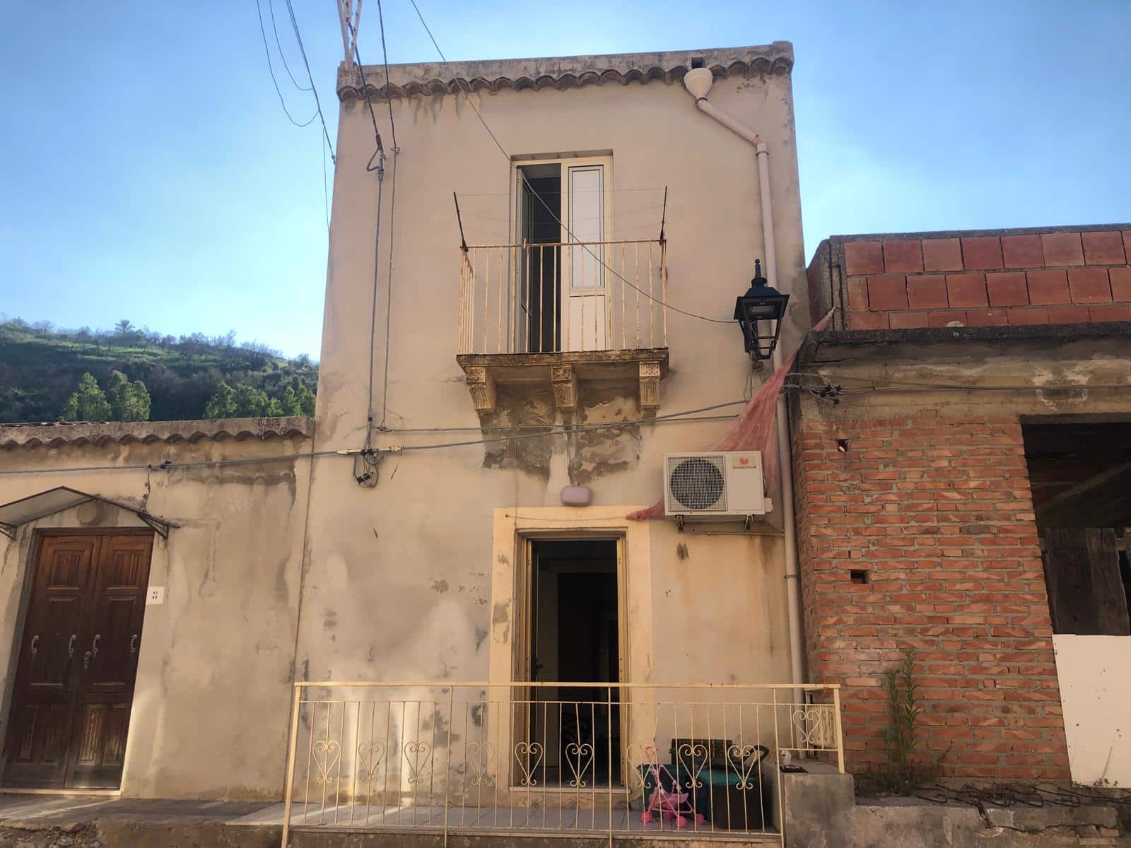 Vecchia casa in stile tradizionale con balcone e affaccio su strada, ristrutturata e pronta per essere valorizzata. Ideale per investimento o ristrutturazione completa, zona tranquilla con vista colline.
