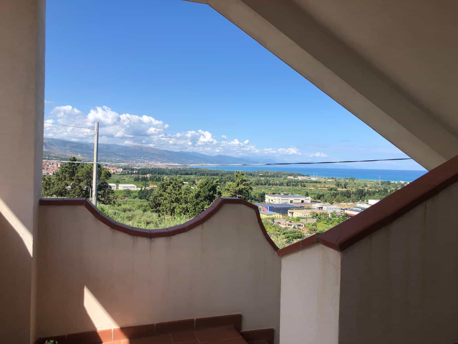 VISTA PANORAMICA dal balcone di una casa moderna, vista mare e montagne, circondata da natura e infrastrutture urbane, in una zona tranquilla e panoramica in Italia.