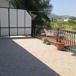 Balcone con vista panoramica, piante e arredamento, zona outdoor soleggiata, prossimità a zone verdi e colline, ideale per relax e spazi esterni in un contesto abitativo tranquillo.