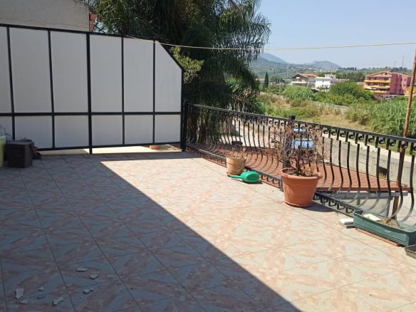 Balcone con vista panoramica, piante e arredamento, zona outdoor soleggiata, prossimità a zone verdi e colline, ideale per relax e spazi esterni in un contesto abitativo tranquillo.
