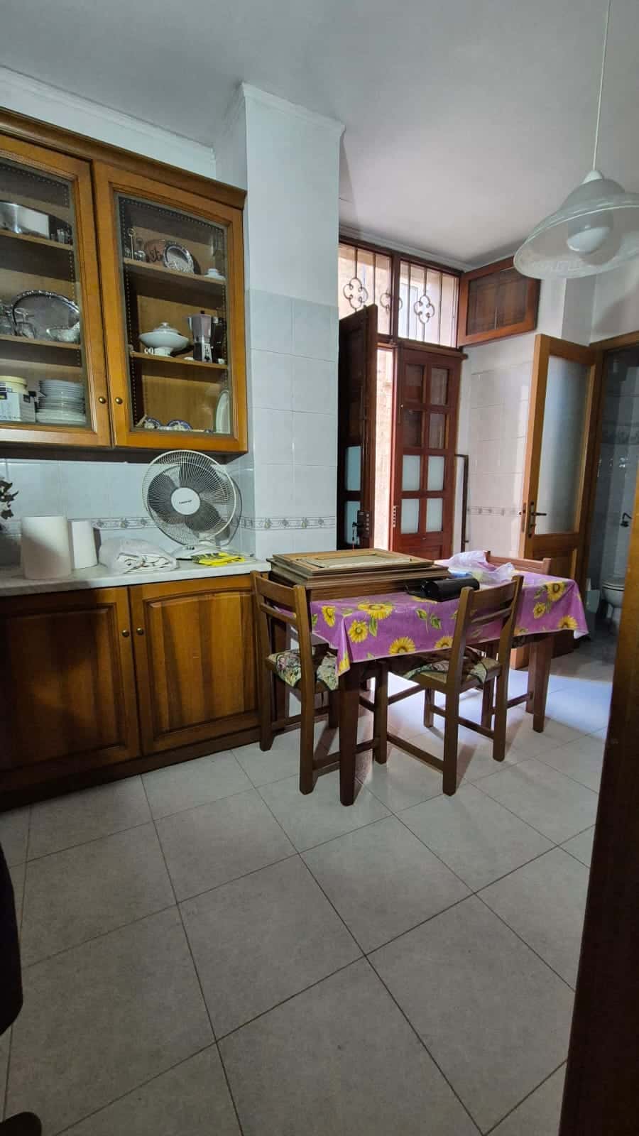 Armadio in legno con vetri e stoviglie in una cucina.