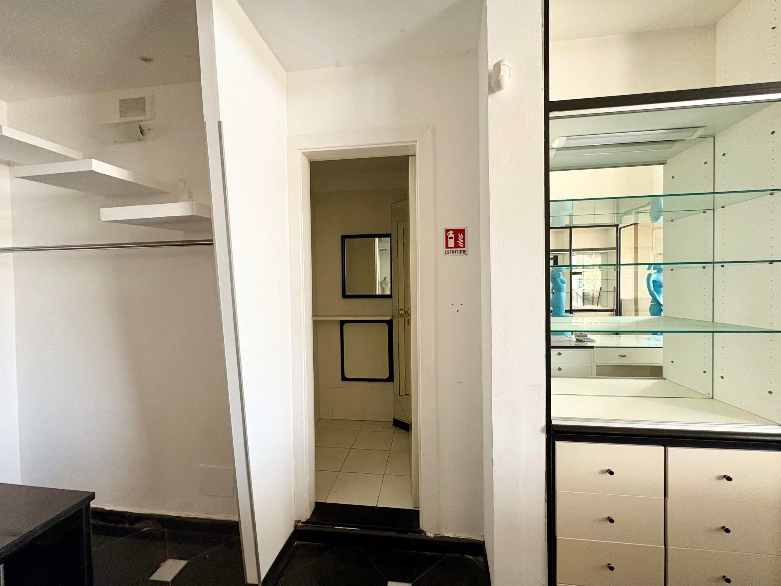Stanza con scaffali in vetro, arredi moderni e spazi efficiente, ideale per ufficio o negozio, perfetta per soluzioni commerciali e di coworking.