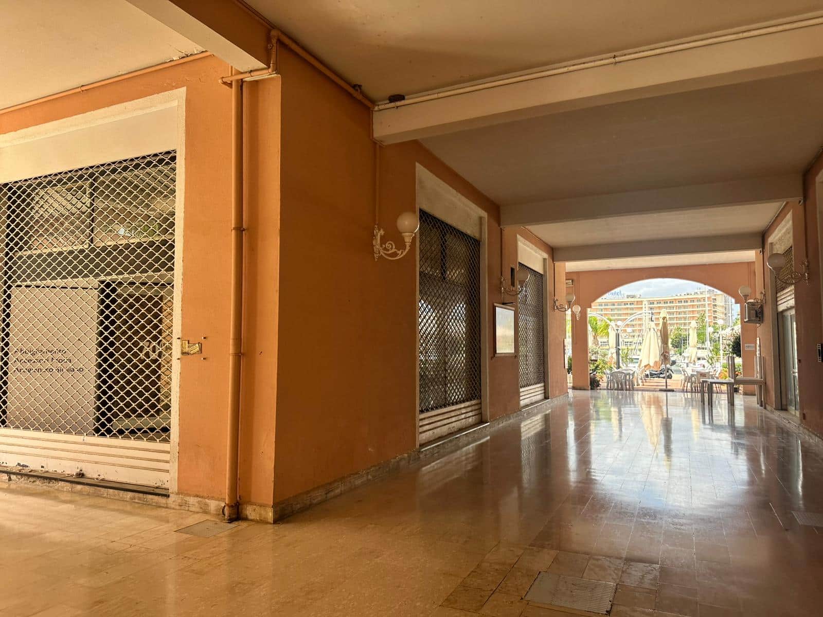 Ampio porticato con pavimento in ceramica, ideale per zone relax all'aperto, con vista sui servizi dell'edificio e sullo spazio esterno con tavoli e sedie. Ottima soluzione per vivere gli spazi comuni.